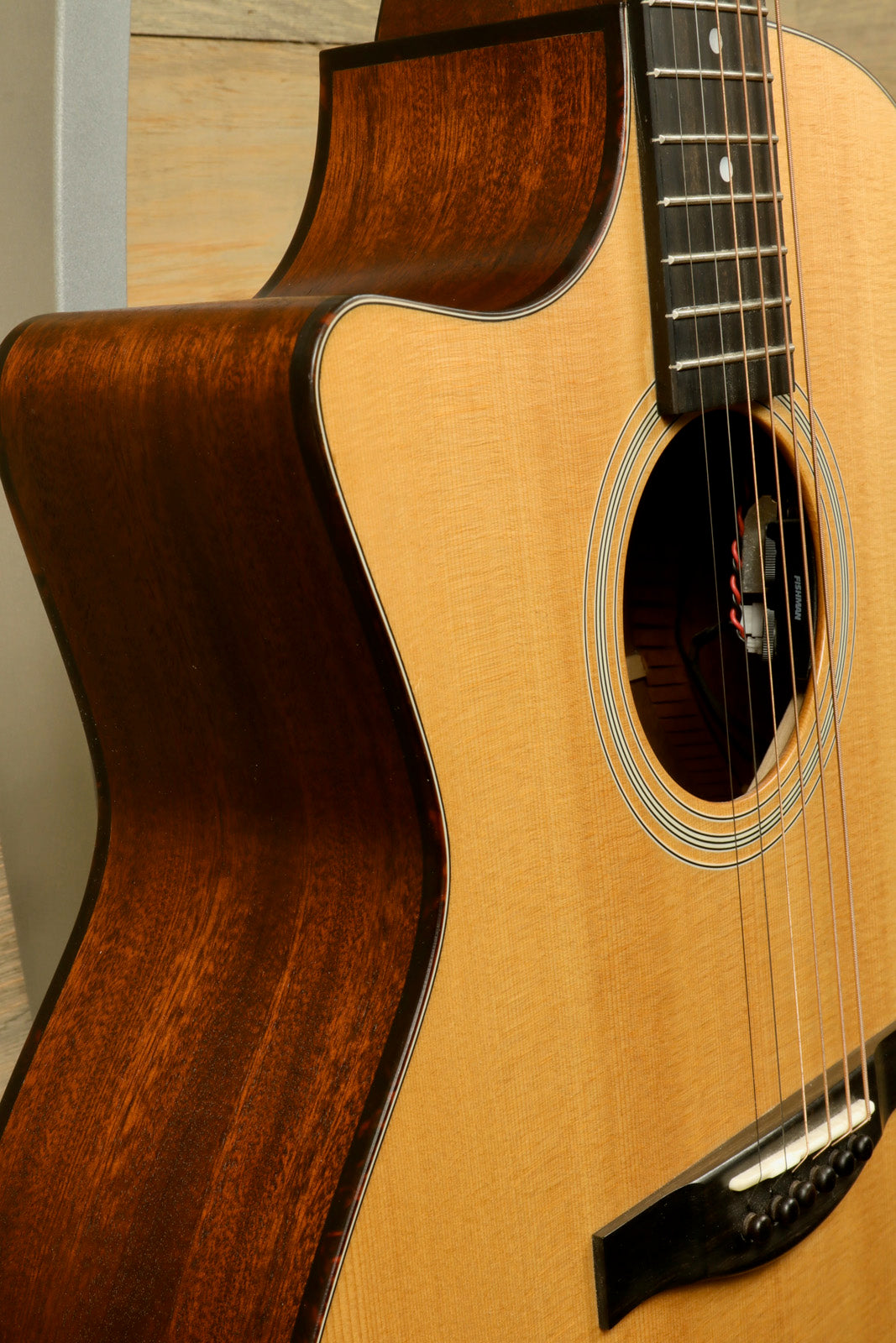 Eastman AC122L-1CE acoustic electric guitar with natural finish, side view showcasing its curves