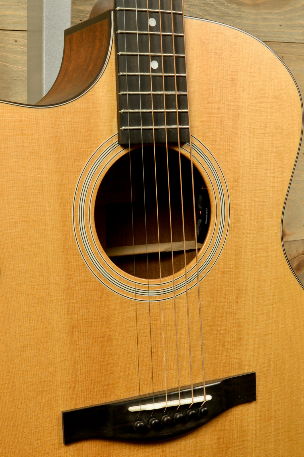 Eastman AC122L-1CE acoustic electric guitar in natural finish, close-up of body and neck.