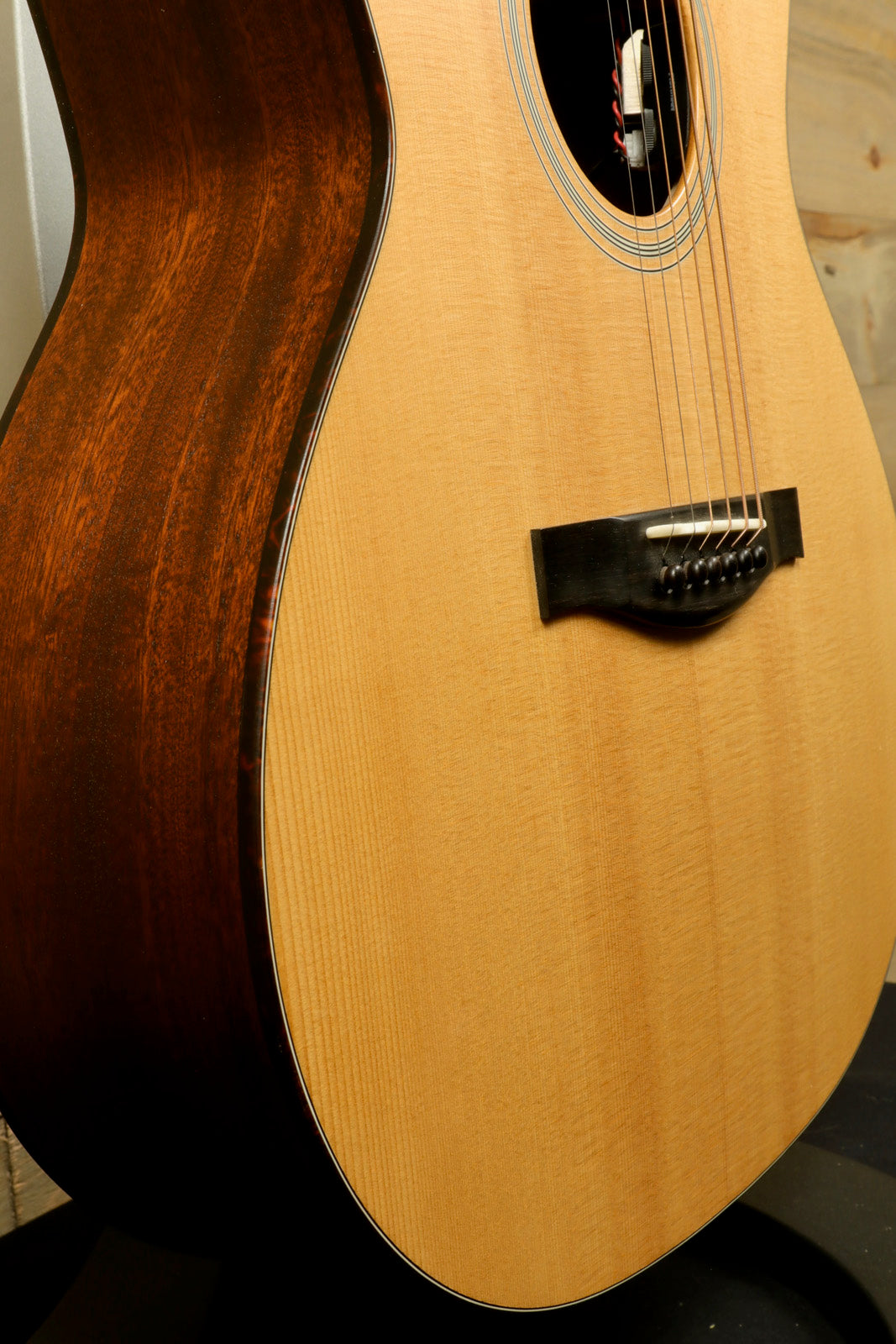 Eastman AC122L-1CE acoustic electric guitar, natural finish, side view highlighting wood grain
