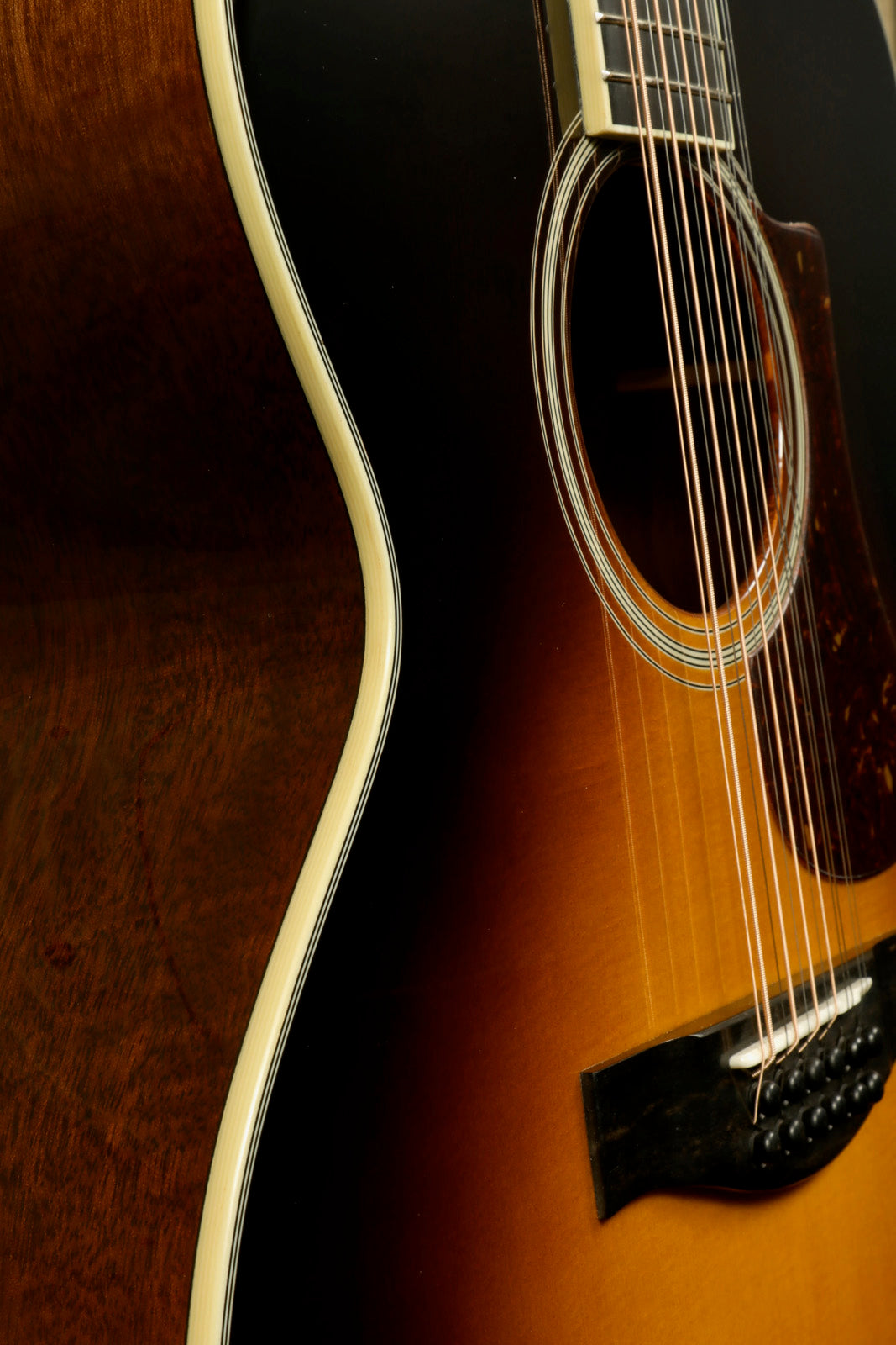 Close-up of Eastman AC330E-12-SB 12-string acoustic guitar showcasing the smooth curves and rich finish
