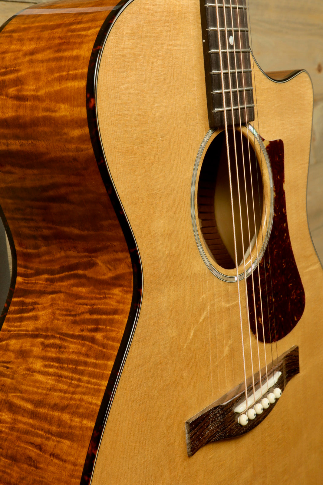 Eastman acoustic guitar in natural finish, showcasing intricate wood grain and soundhole detail, front view