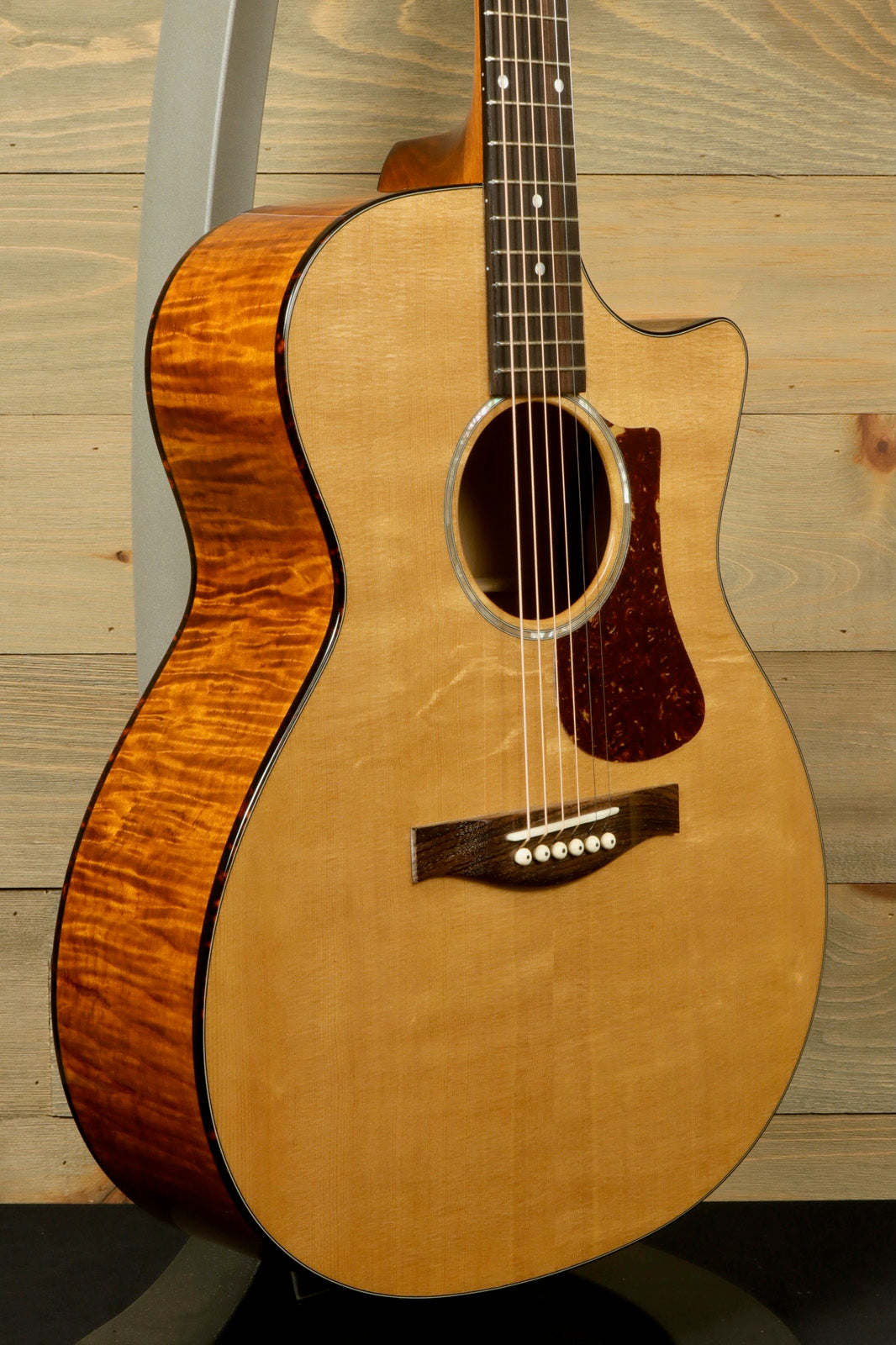 Eastman acoustic guitar, with a natural finish and detailed wood grain, angled view