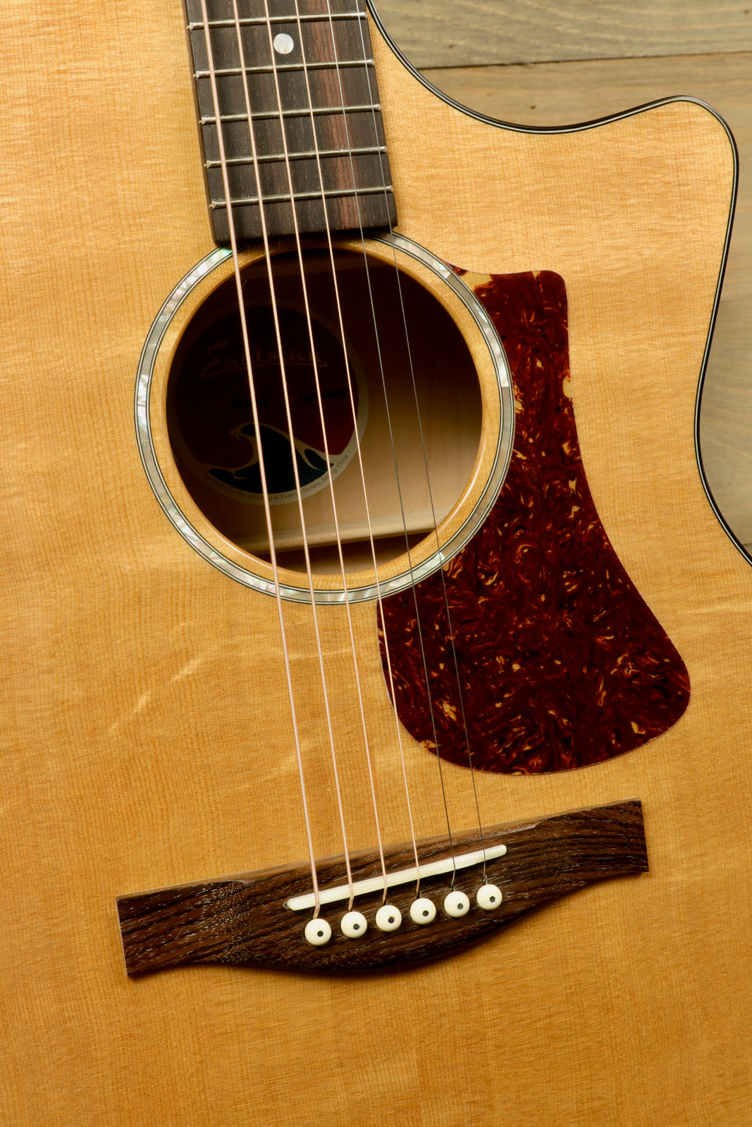Eastman acoustic guitar natural finish, close-up view of soundhole and fretboard details