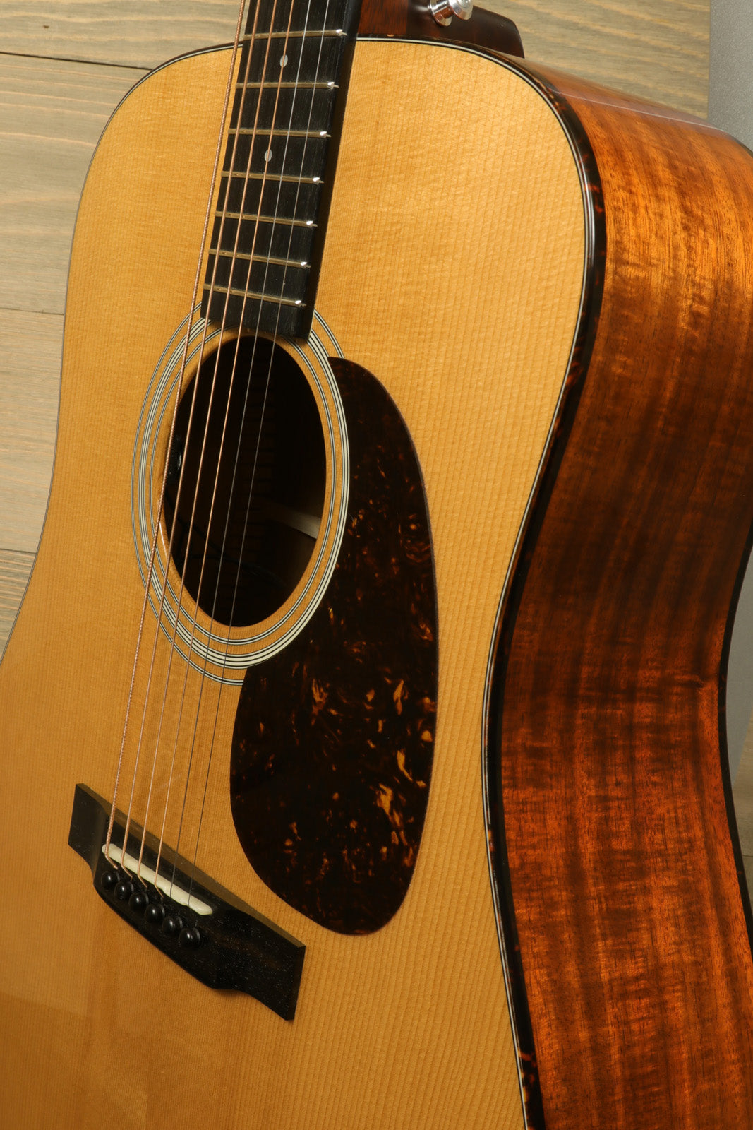 Eastman E10D-TC acoustic electric guitar in sunburst finish, side view showcasing wood grain.