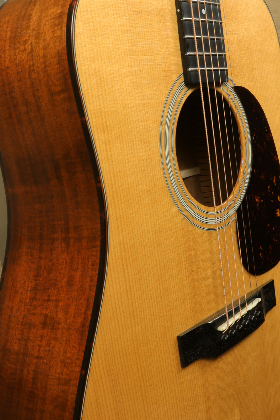 Eastman E10D-TC acoustic electric guitar with a natural finish, side view showcasing its wood grain