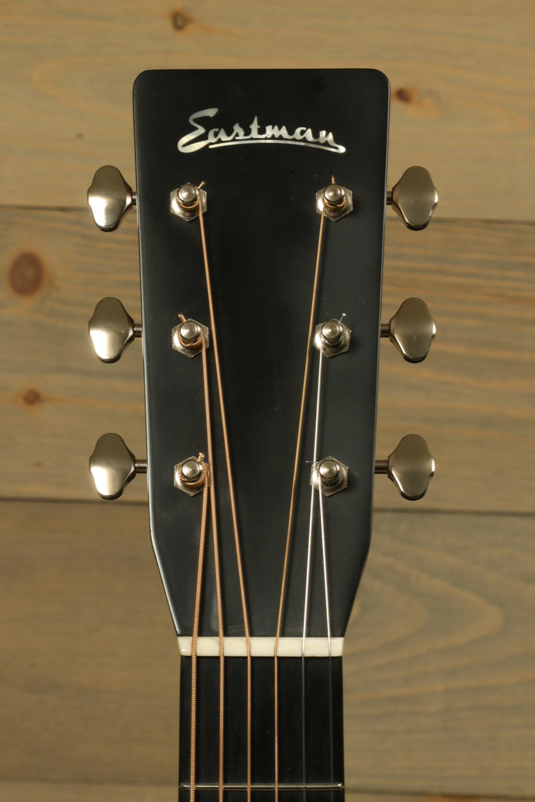 Eastman E10D-TC acoustic electric guitar, black headstock with silver tuning pegs, front view