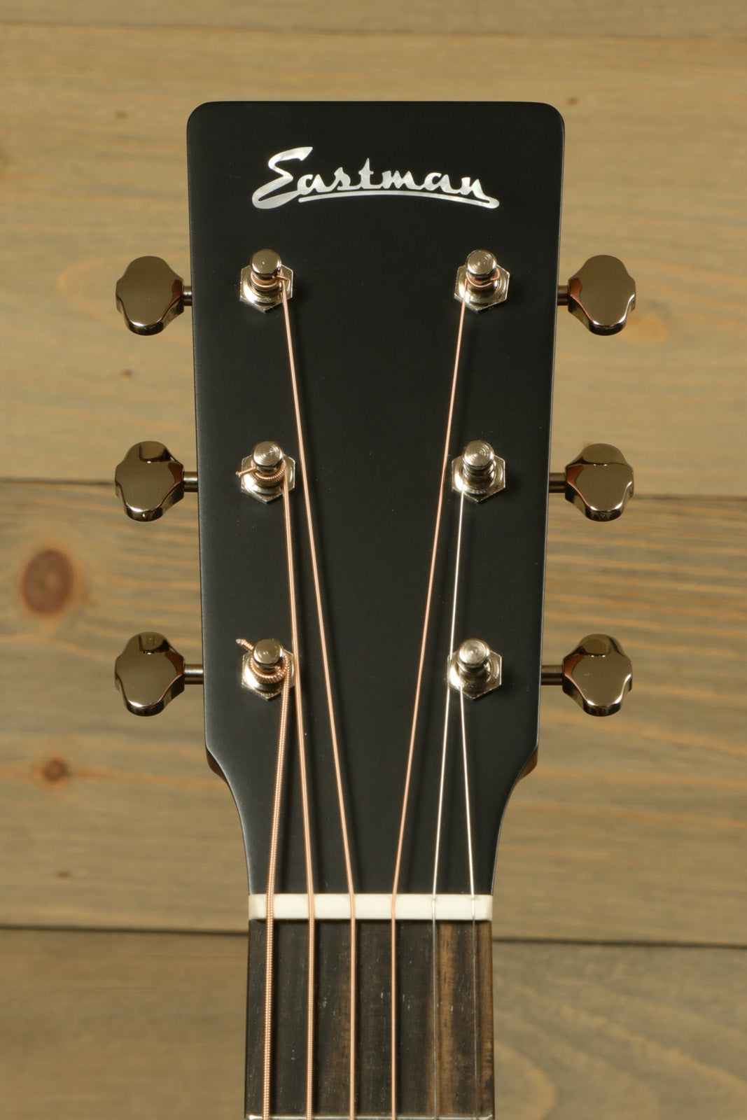 Eastman E1D-CLA acoustic guitar, matte black headstock, front view with tuning pegs