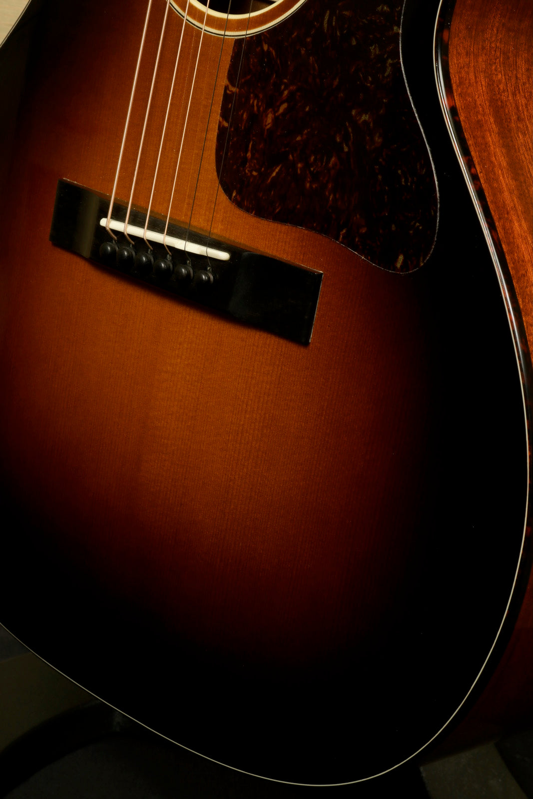 Eastman E1OOSS-DLX-SB acoustic guitar in sunburst finish, close-up view of the body