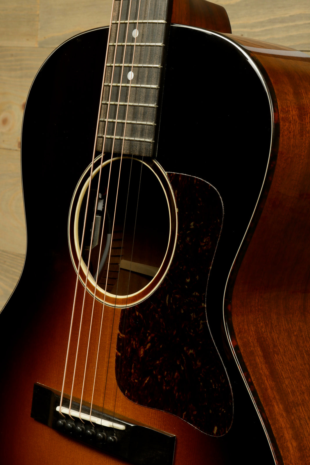Eastman E1OOSS-DLX-SB acoustic guitar in sunburst finish, close-up view of the body and neck