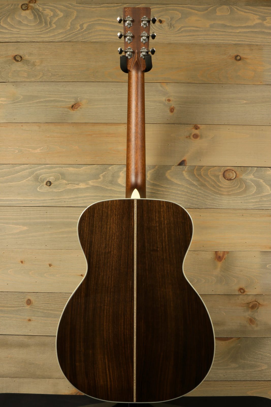 Back view of Eastman E8OM-TC acoustic guitar featuring a beautifully crafted dark wood finish