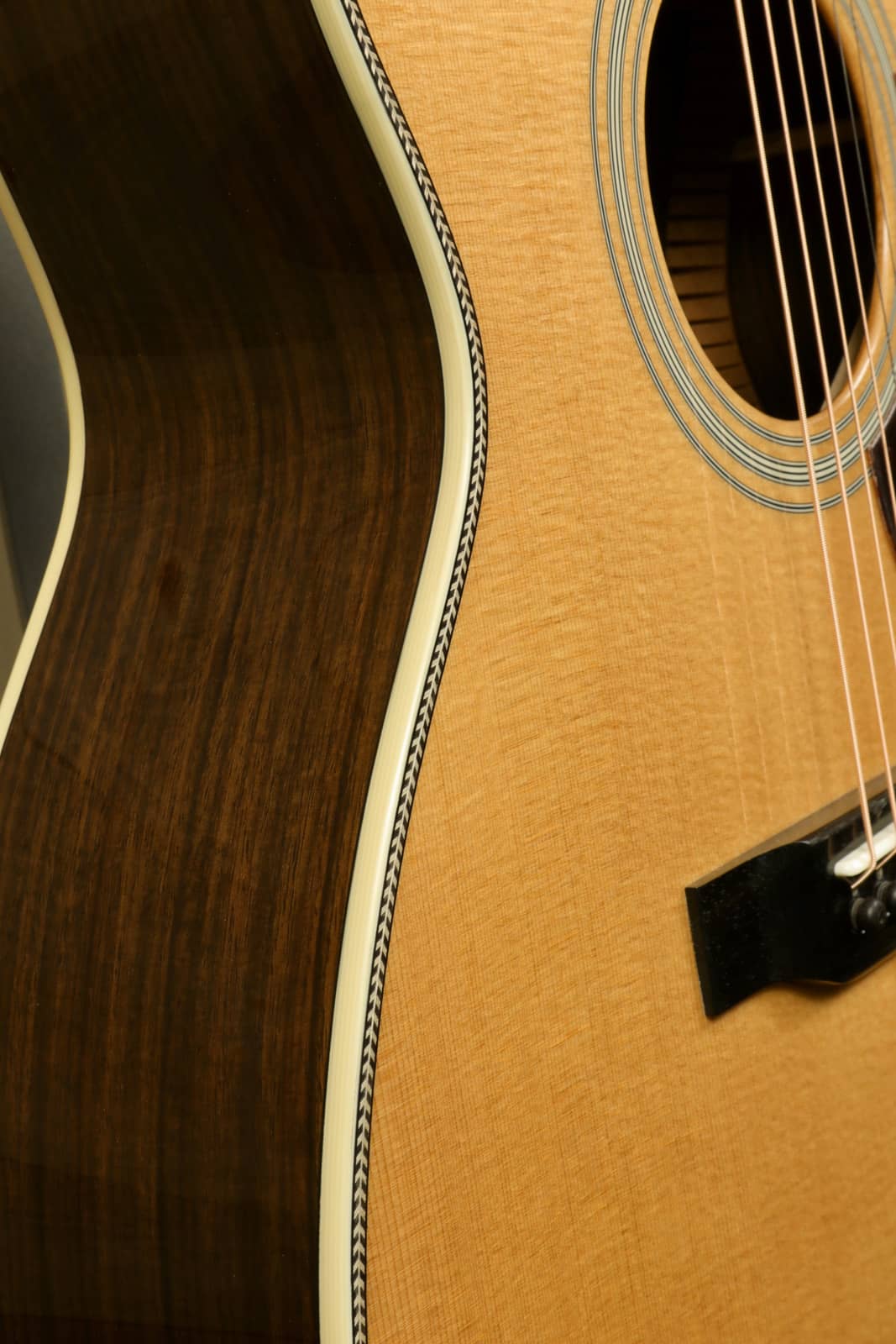 Close-up of Eastman E8OM-TC acoustic guitar showcasing its smooth body curves and rich wood grain
