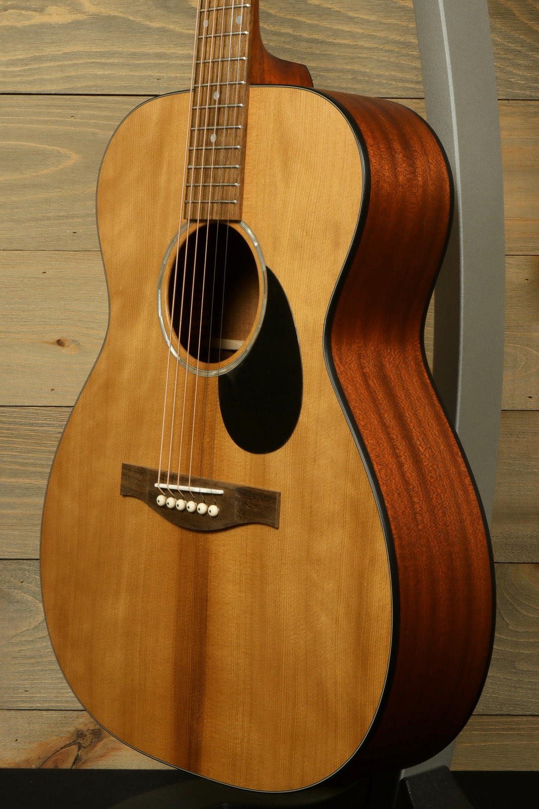 Eastman PCH1-OM acoustic guitar in natural finish, side view showcasing the body and texture