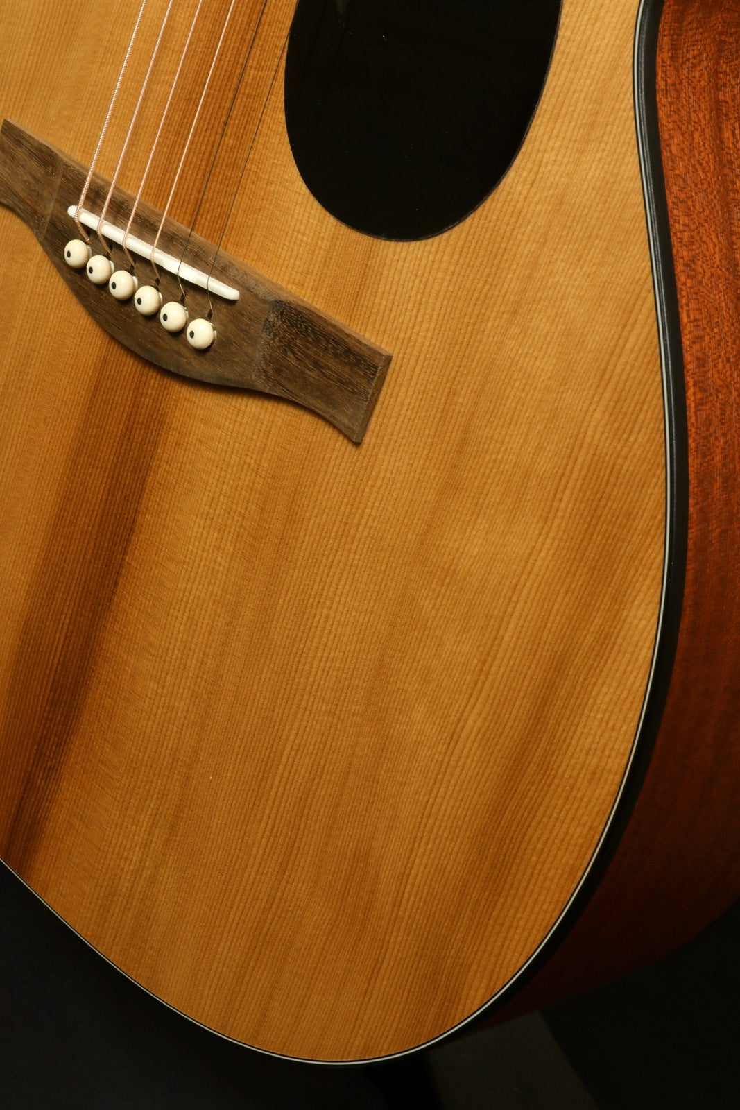 Eastman PCH1-OM acoustic guitar, natural wood finish, close-up view of the body and bridge