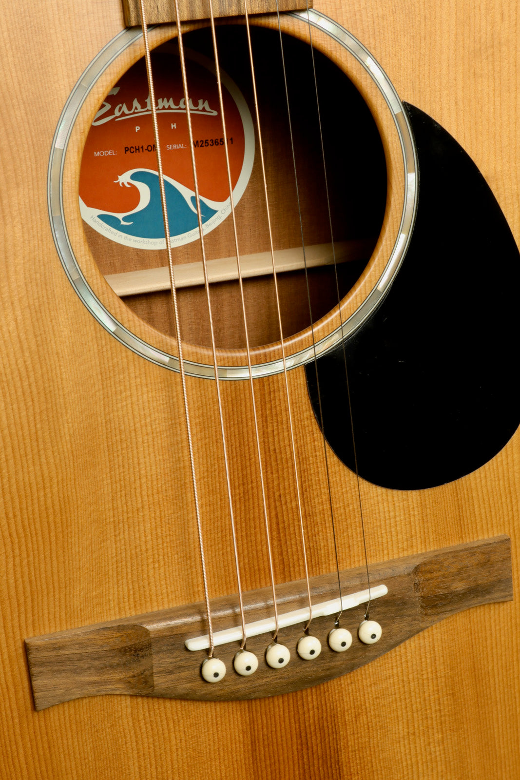 Eastman PCH1-OM acoustic guitar, natural wood finish, front view showcasing the soundhole and strings