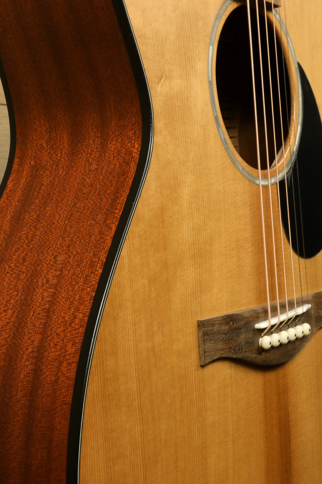 Eastman PCH1-OM acoustic guitar, natural finish, side view showcasing rich wood grain