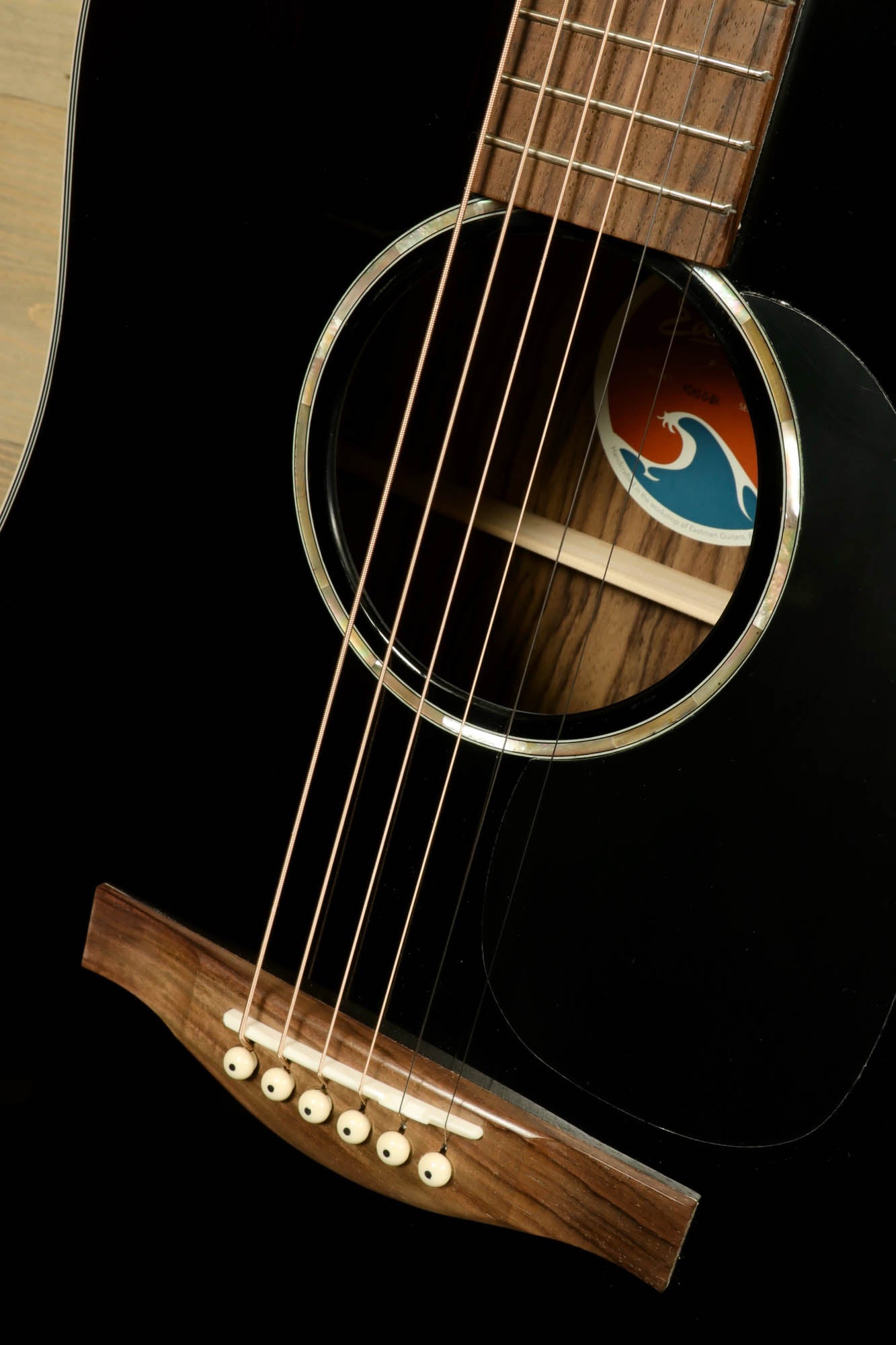 Close-up of Eastman PCH2-D-BK acoustic guitar featuring a sleek black finish and detailed soundhole design
