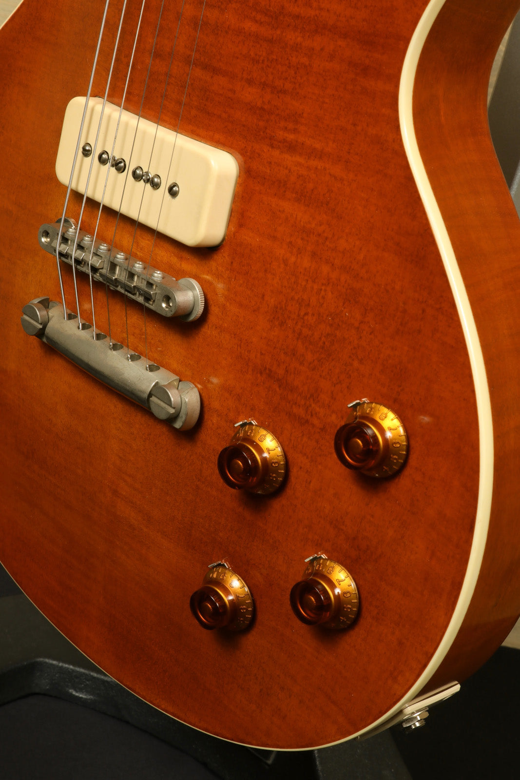 Eastman SB56/TV-AMB electric guitar in amber finish, showcasing controls and pickups from side view