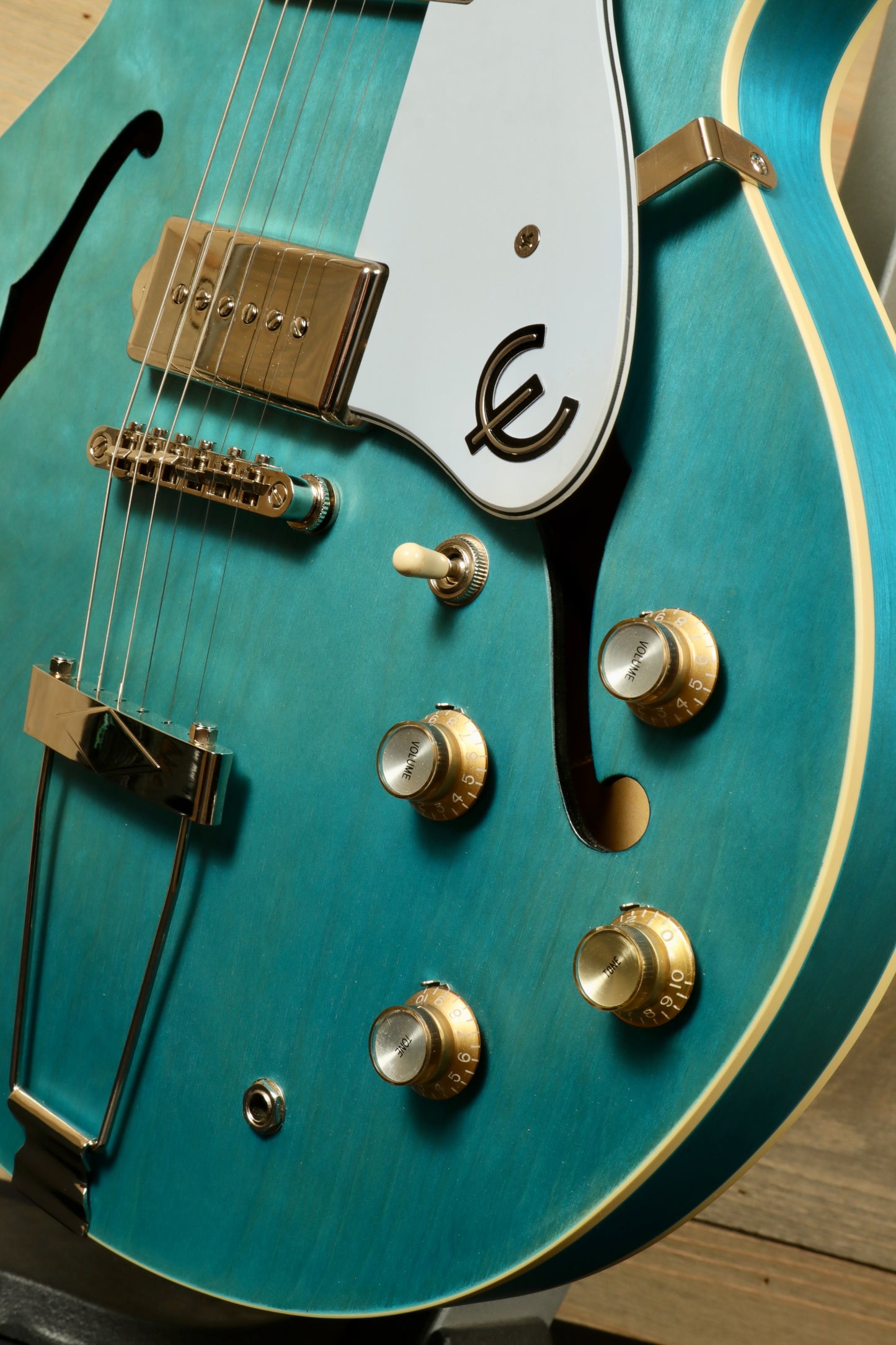 Epiphone Casino Worn in teal with gold knobs, side view showcasing hollow body design