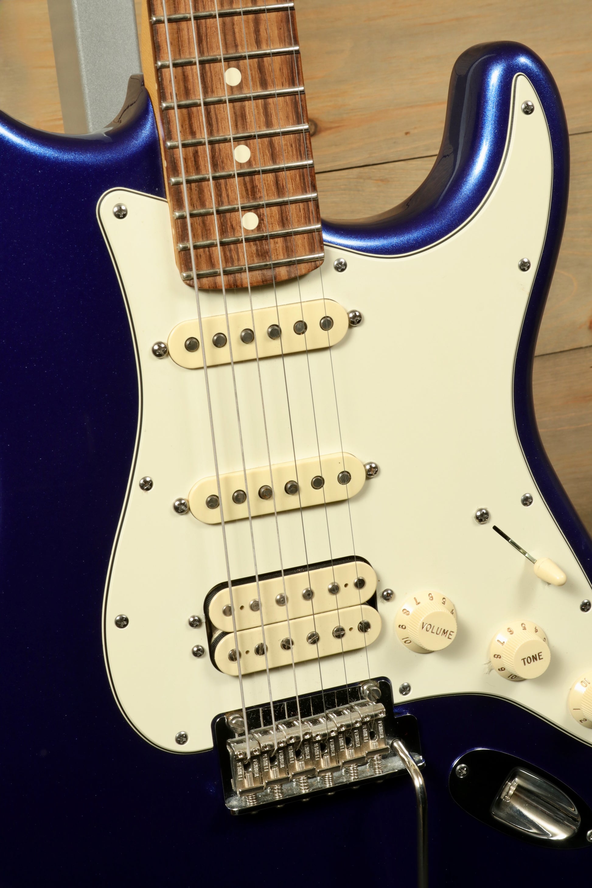 Close-up of a used Fender American Standard Stratocaster HSS in blue with vintage-style pickups and controls