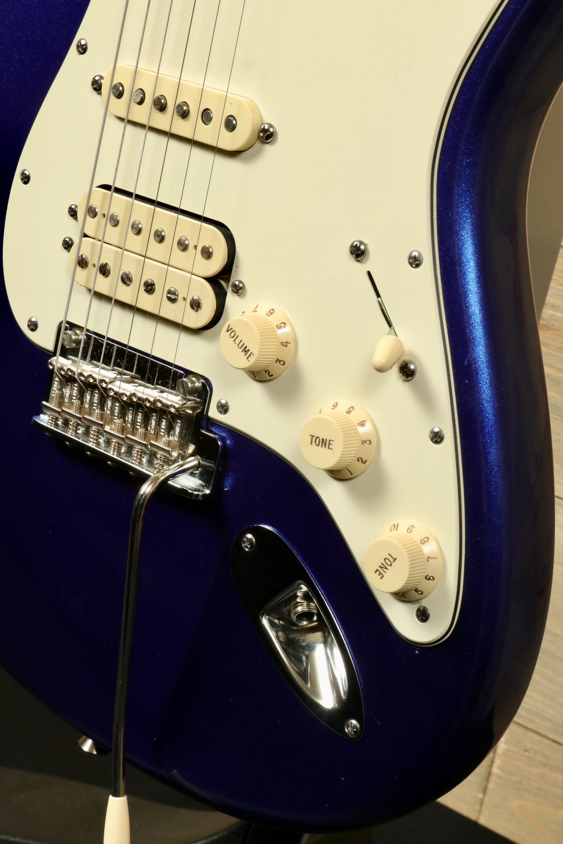 Close-up of a used Fender American Standard Stratocaster HSS with volume and tone controls