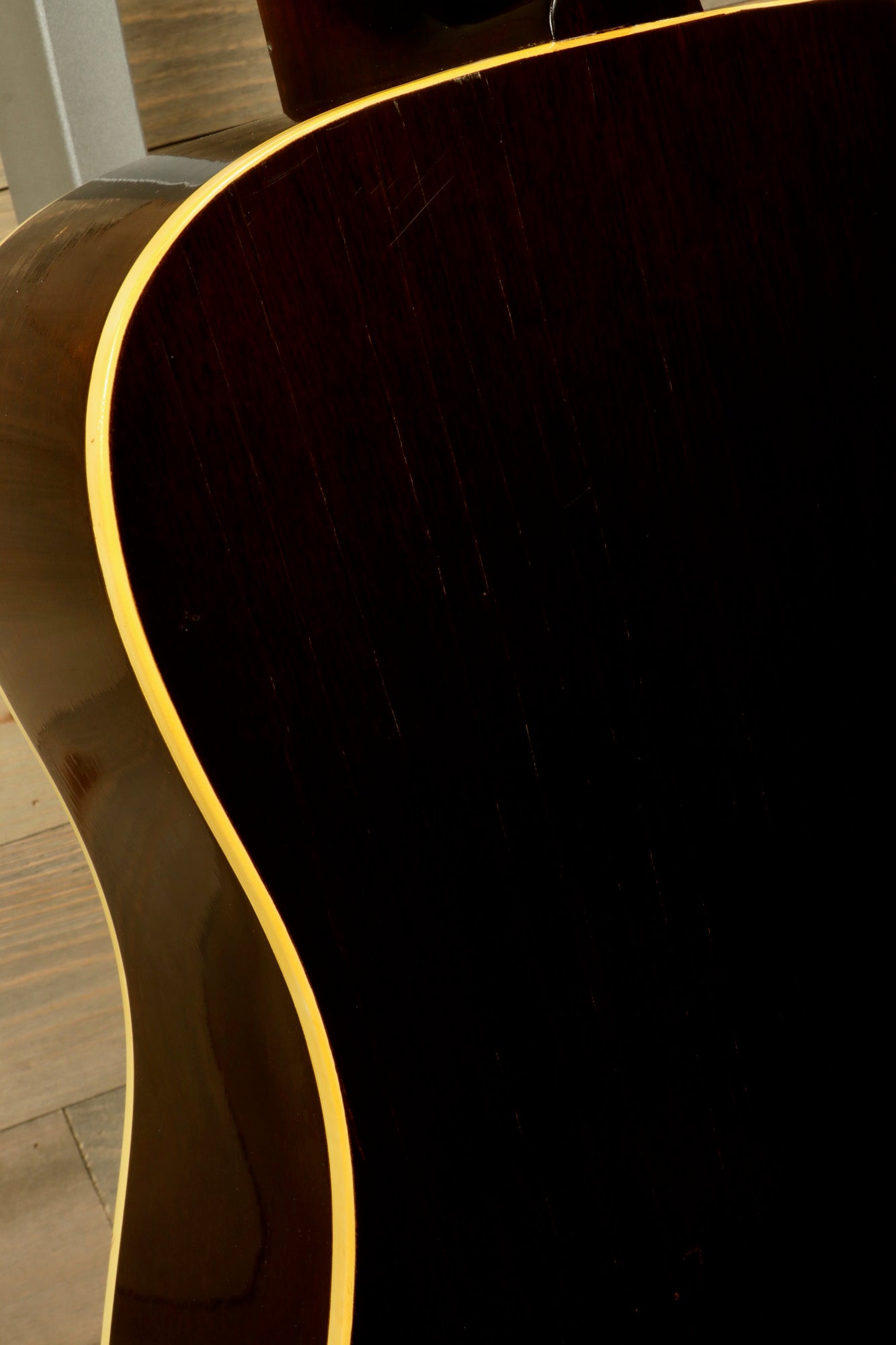 Close-up of the back of a 1968 Gibson J-50 Deluxe for sale showcasing rich wood grain and elegant curves