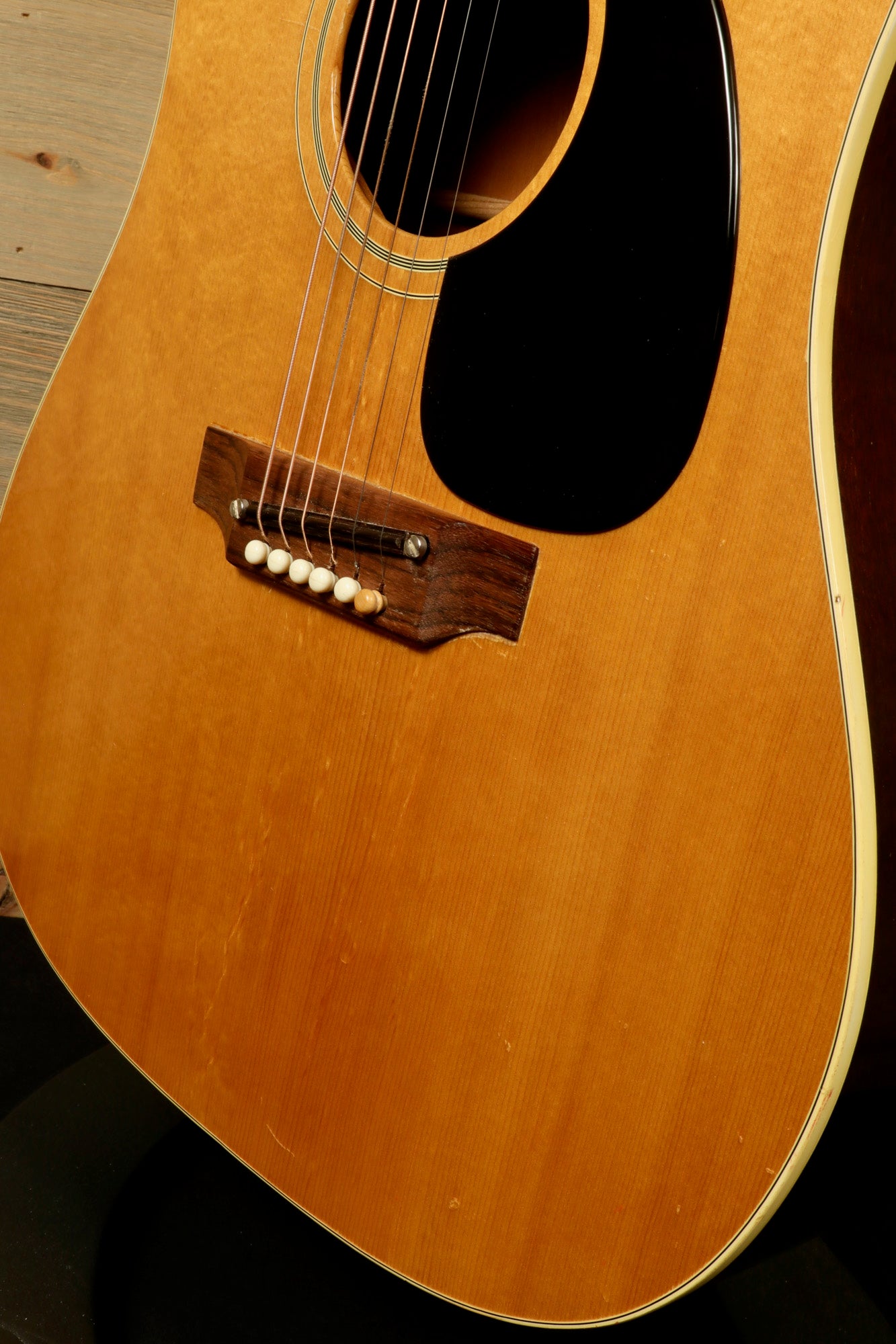 Close-up of 1968 Gibson J-50 Deluxe for sale showcasing the body and bridge details