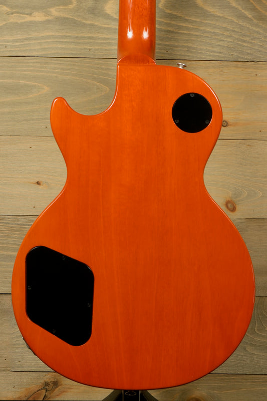 Gibson Les Paul Studio electric guitar in vibrant orange, back view showcasing smooth finish and control cavity.