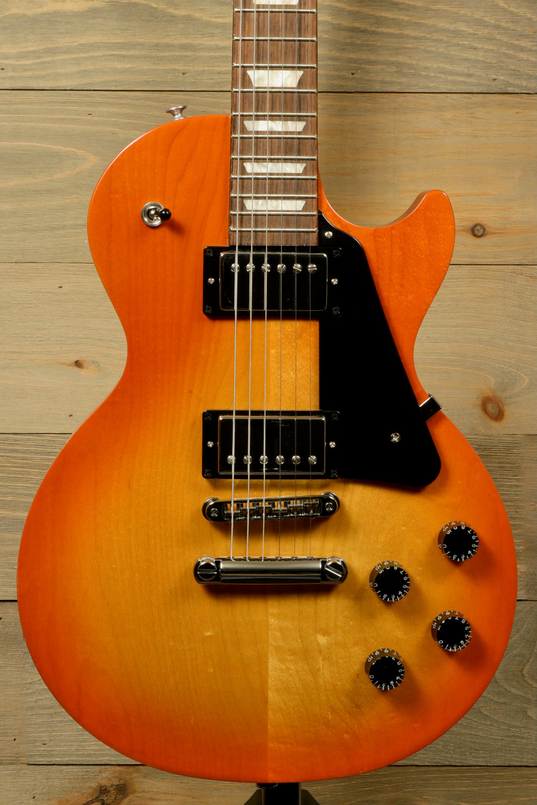 Gibson Les Paul Studio in an orange sunburst finish, front view showcasing the body and pickups