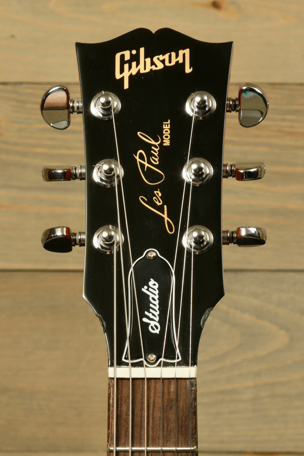 Gibson Les Paul Studio black headstock with logo and tuning pegs, front view
