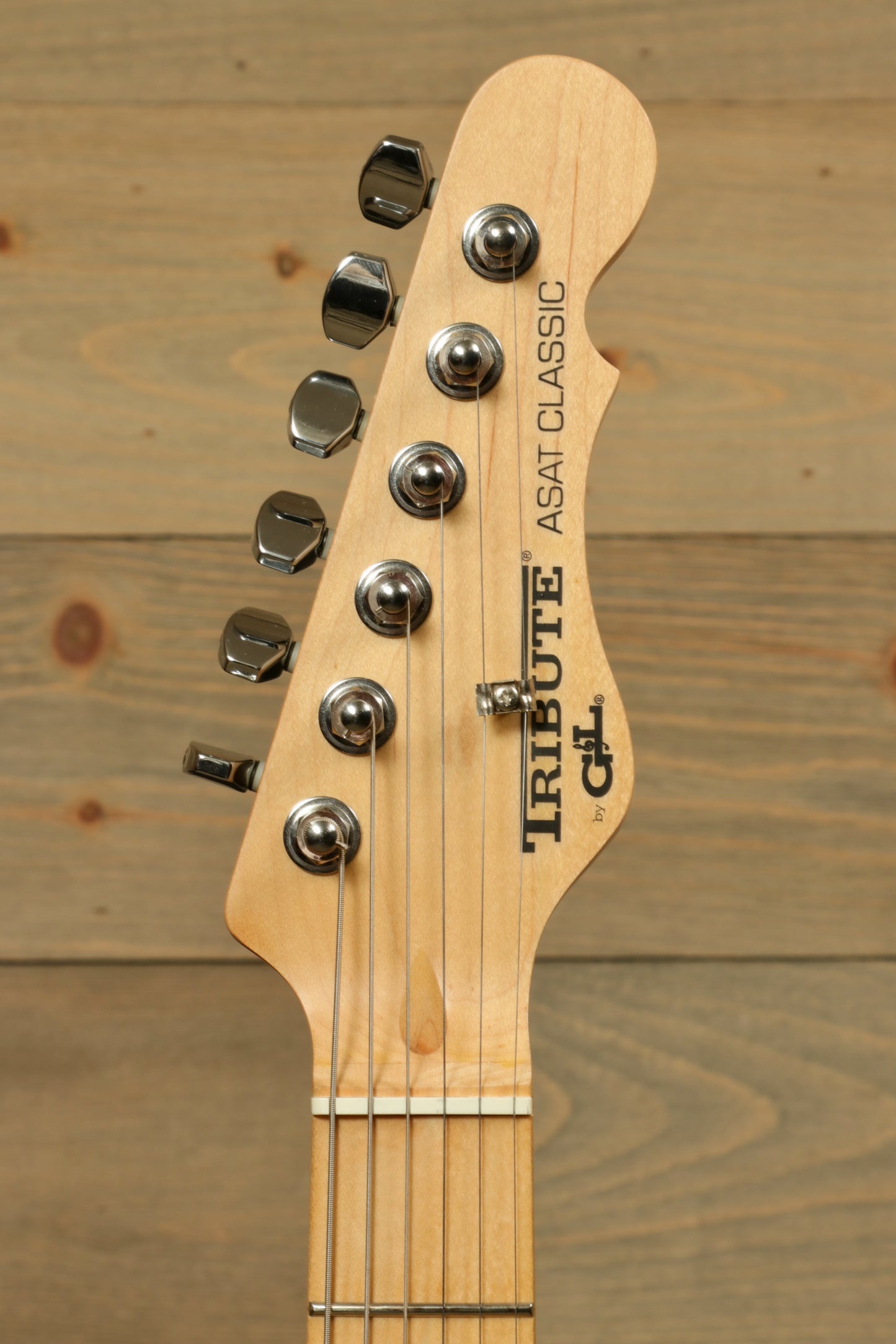 G&L Tribute ASAT Classic electric guitar headstock with polished chrome tuners and natural wood finish