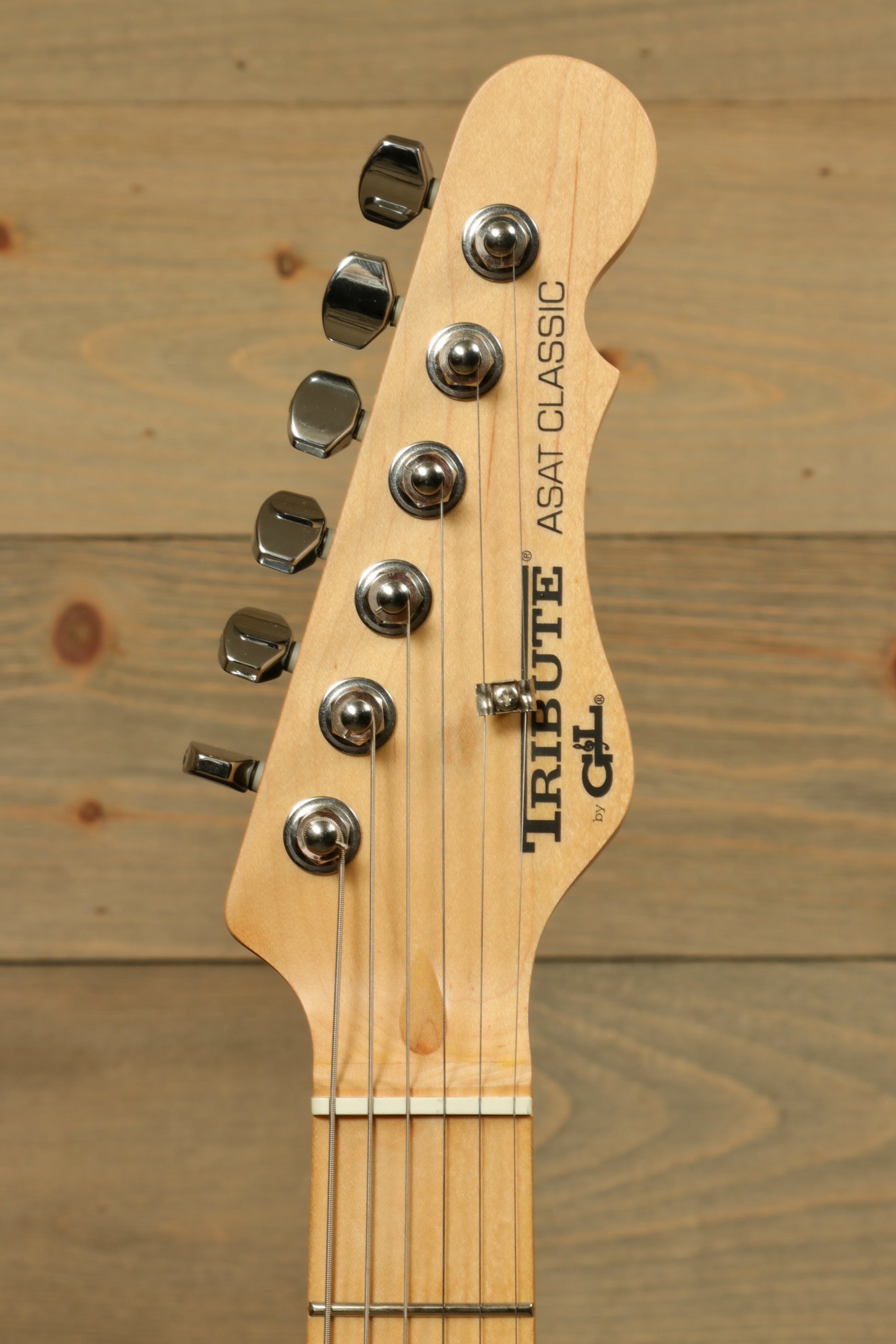G&L Tribute ASAT Classic electric guitar headstock with polished chrome tuners and natural wood finish