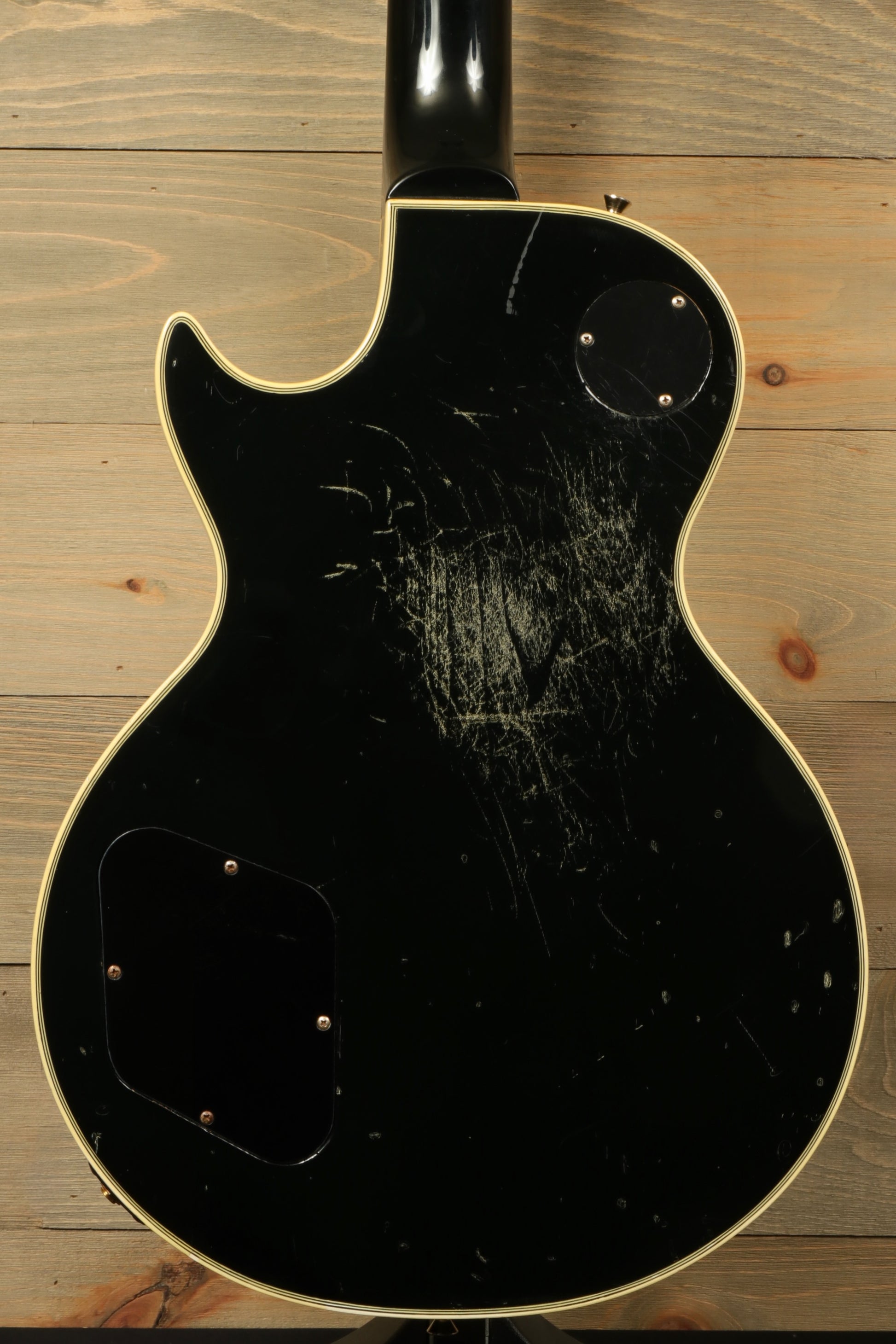 Greco guitar, black finish, back view showcasing scratches and wear on body