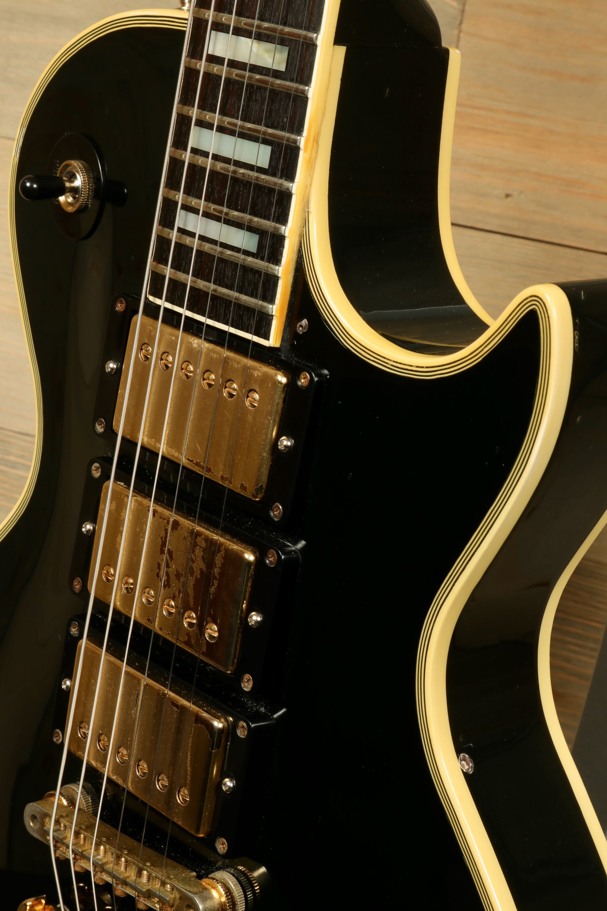 Greco guitar electric model in black finish with gold hardware and detailed fretboard, side view