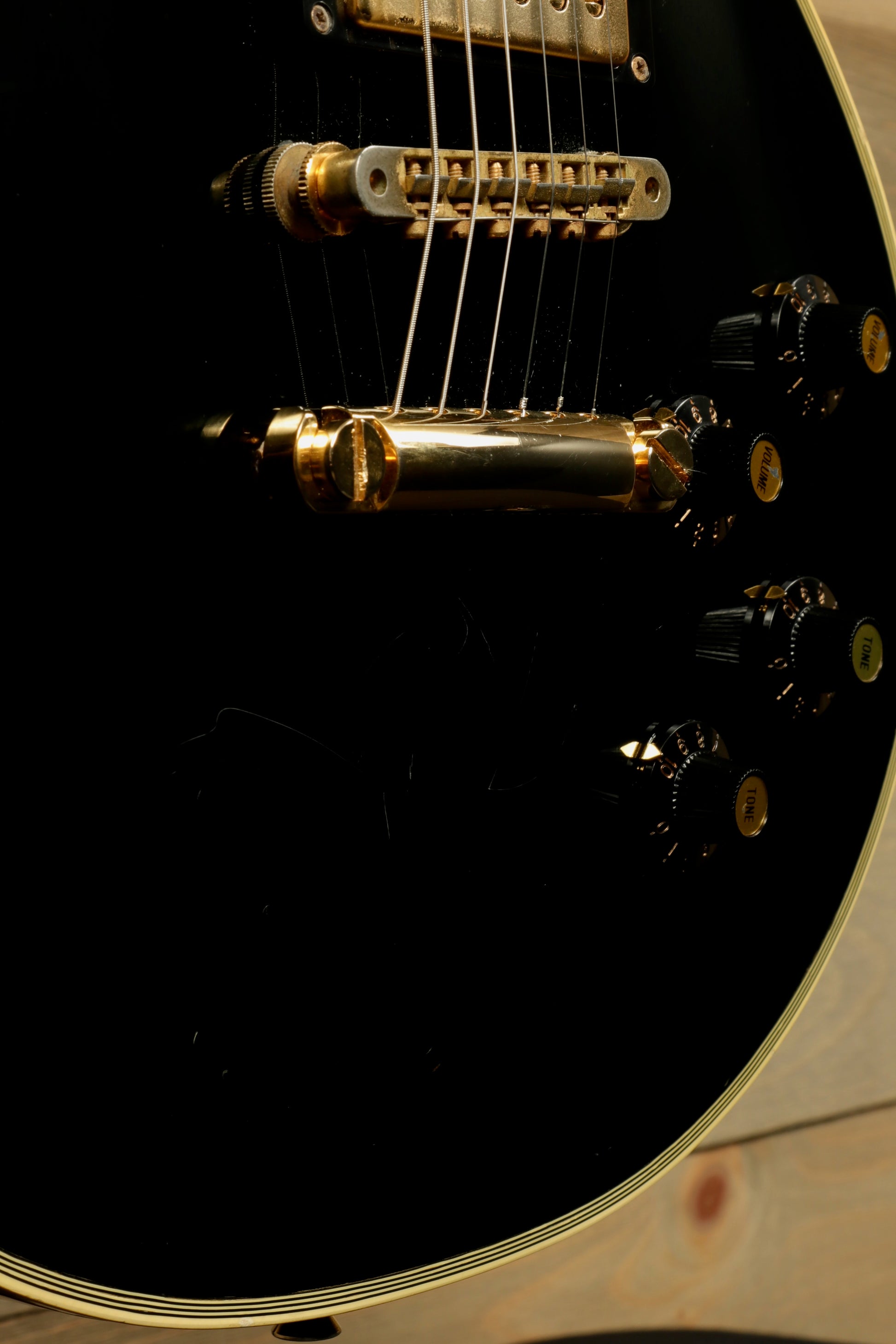 Greco guitar black finish with gold hardware, close-up view of body and controls
