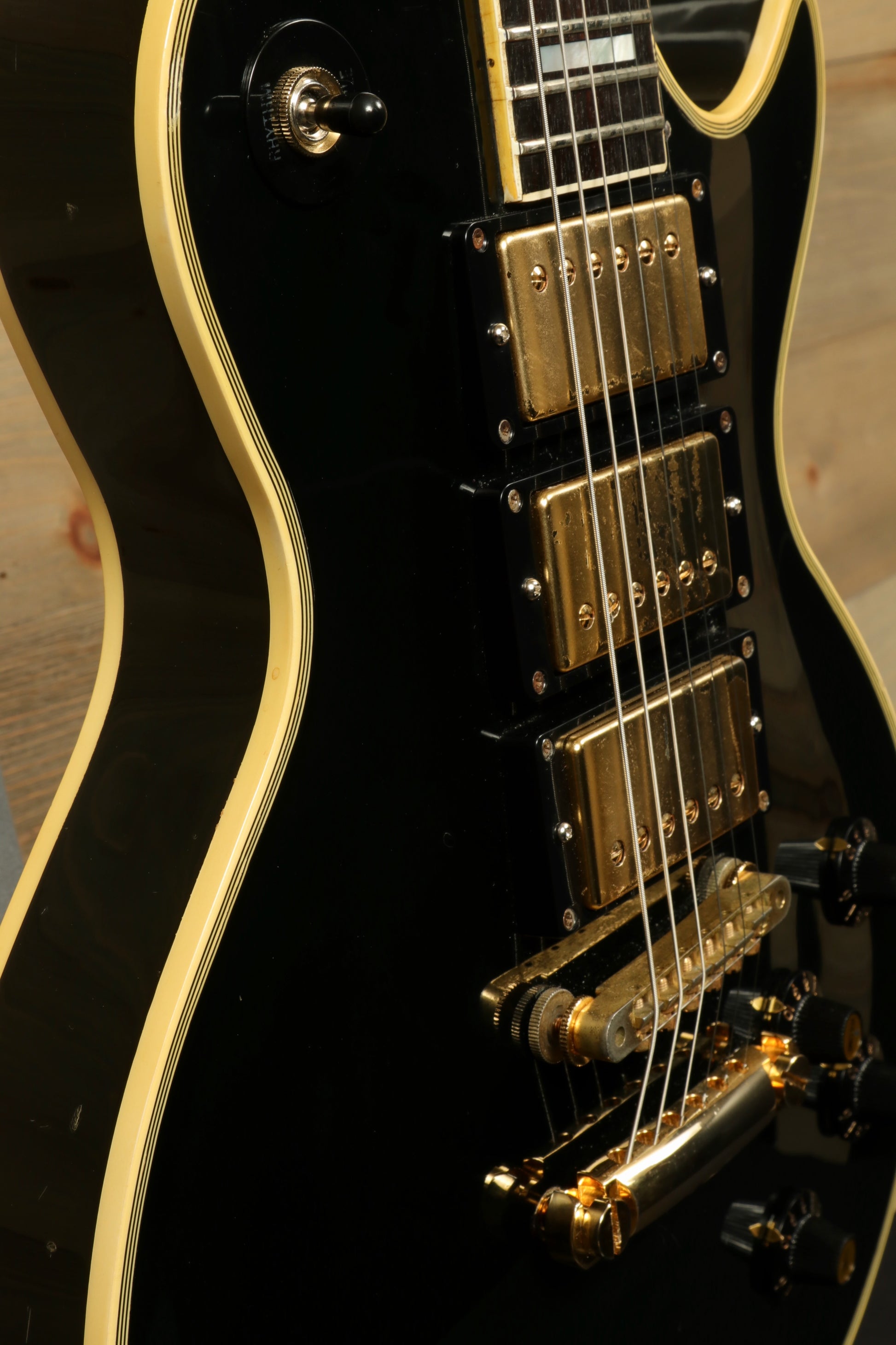 Greco electric guitar in black finish with gold hardware, side view showcasing its elegant design