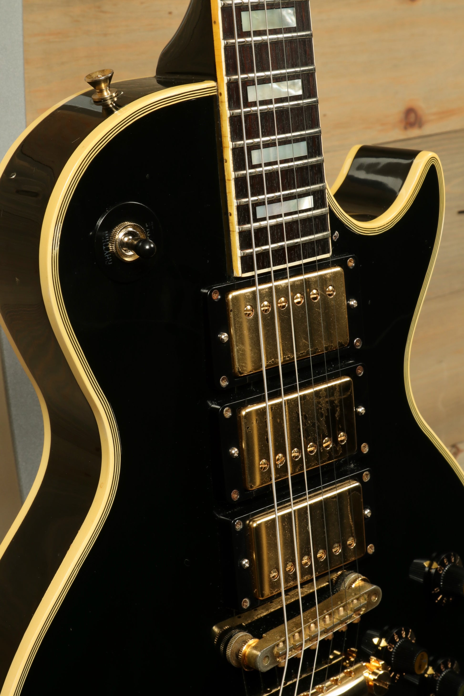 Greco electric guitar in black finish with gold hardware, close-up view of the body and neck