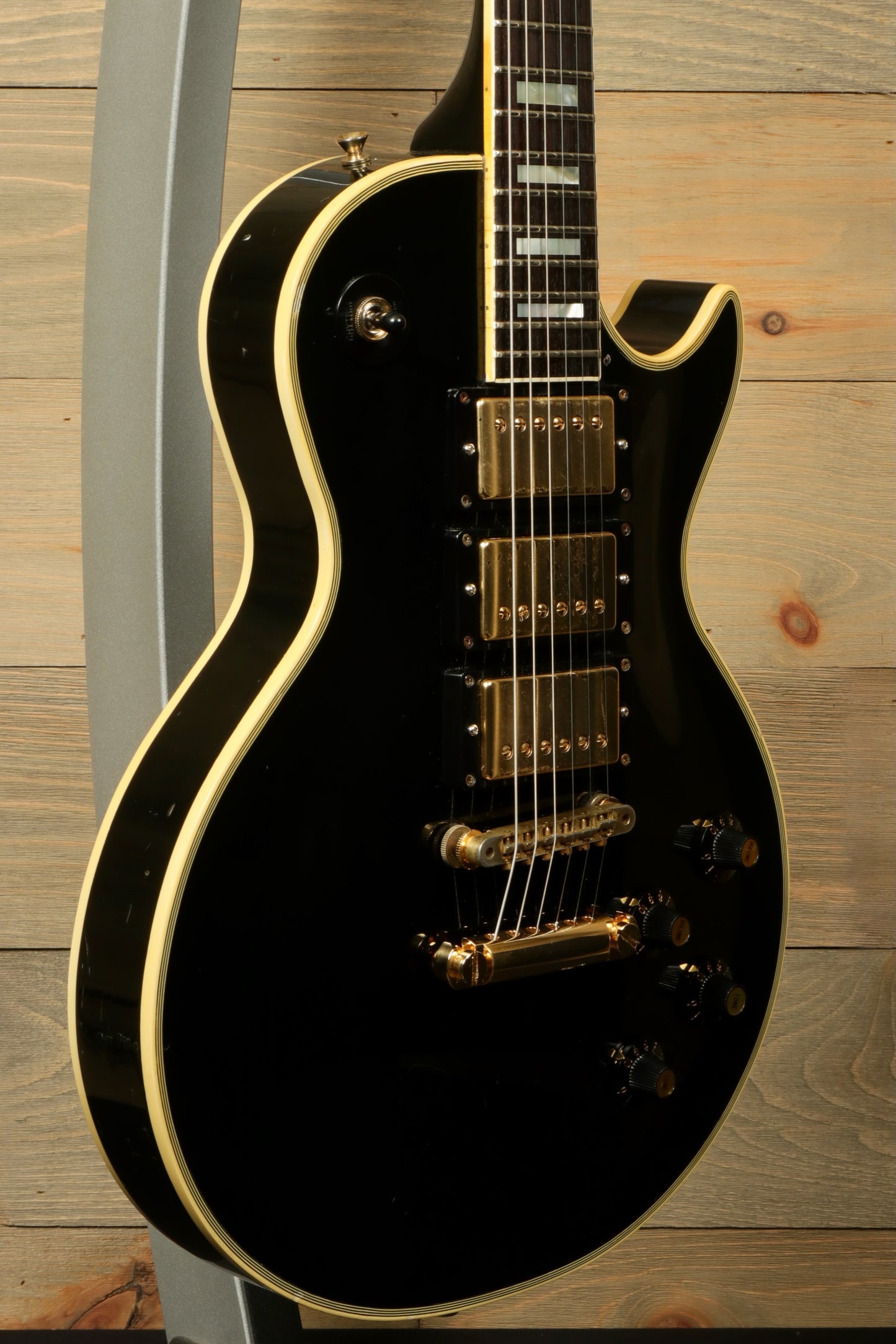 Greco electric guitar in black with gold hardware, side view showcasing design details