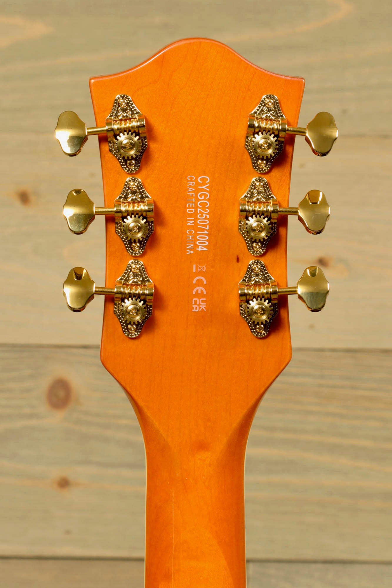 Close-up of the headstock of a Gretsch Synchromatic Nashville hollow body guitar with golden tuning pegs
