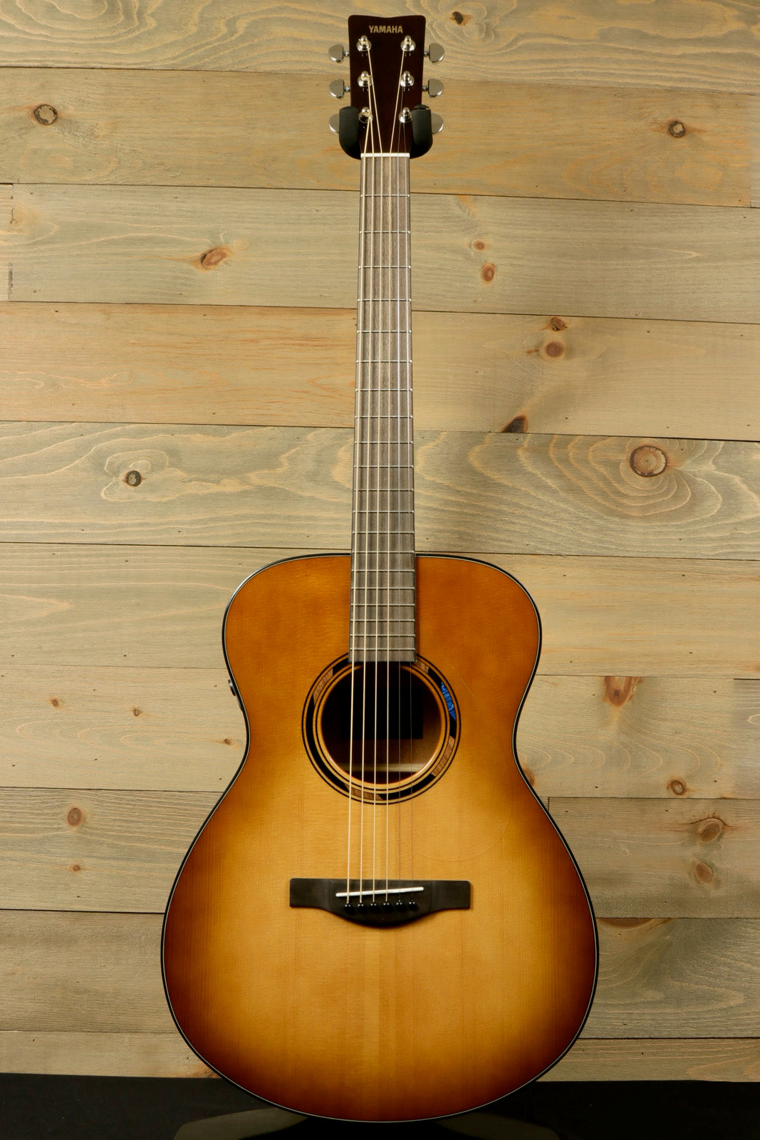 Yamaha acoustic electric guitar in natural finish, front view showcasing the smooth design
