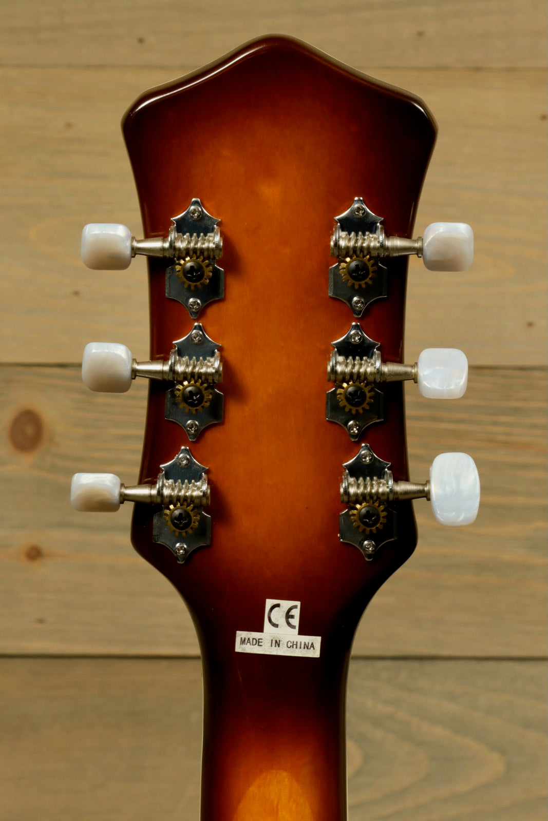 Hofner Guitar with a smooth brown finish, featuring a headstock view and vintage tuning pegs