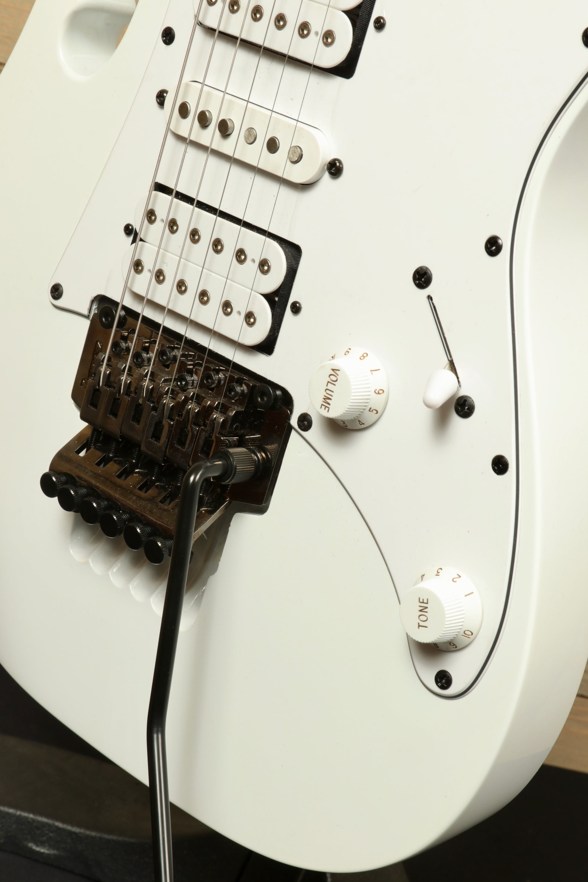 Ibanez JEMJR Steve Vai white electric guitar, close-up of pickups and controls