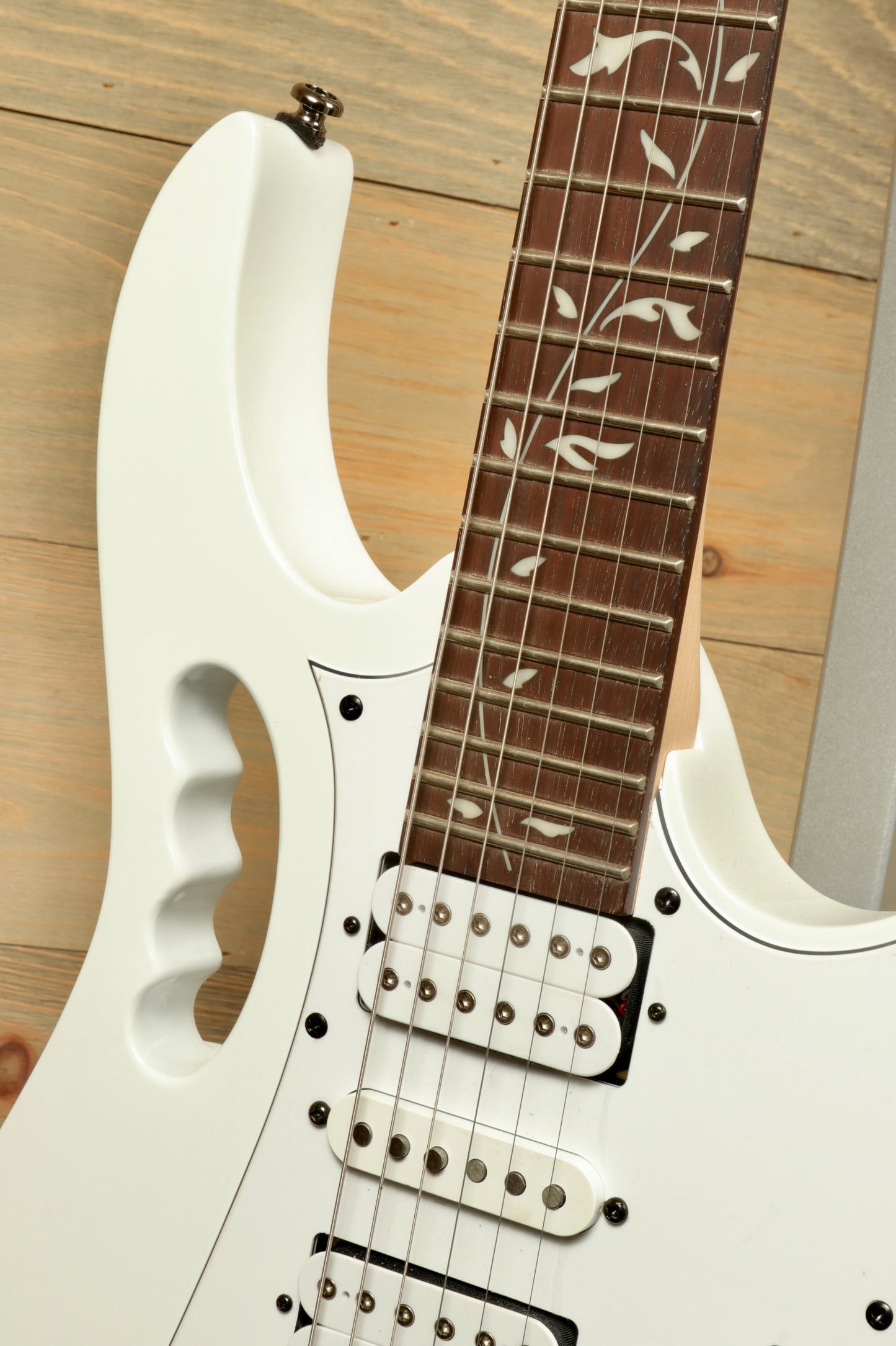 Ibanez JEMJR Steve Vai white guitar with floral inlays, front view showcasing pickups and fretboard