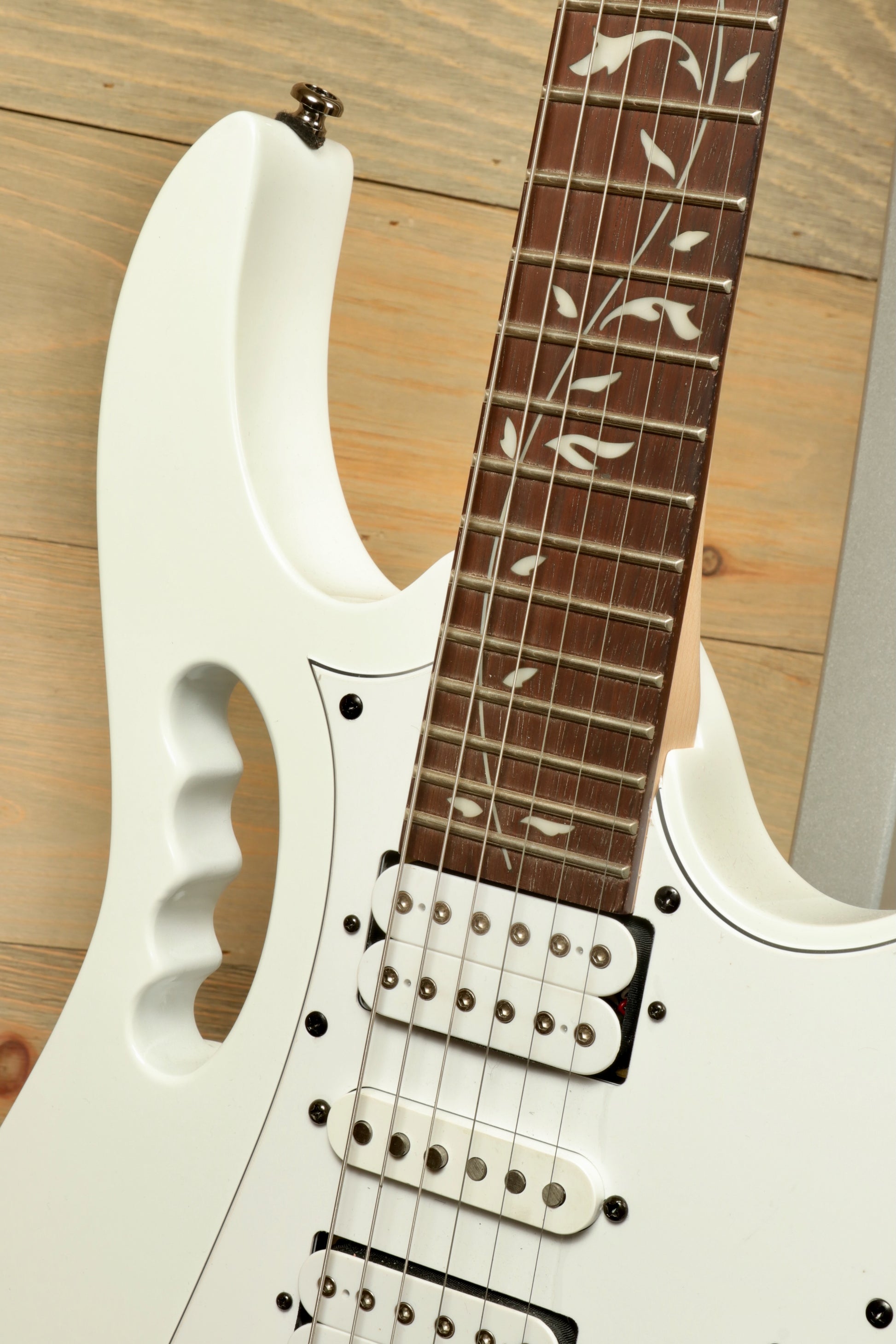 Ibanez JEMJR Steve Vai white guitar with floral inlays, front view showcasing pickups and fretboard