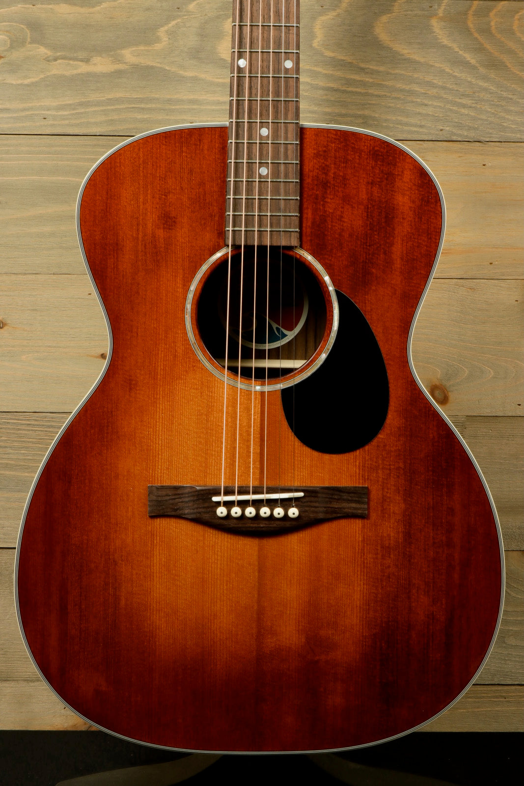 Eastman PCH2-OM-CLA acoustic guitar with a sunburst finish, front view showcasing its beautiful wood grain
