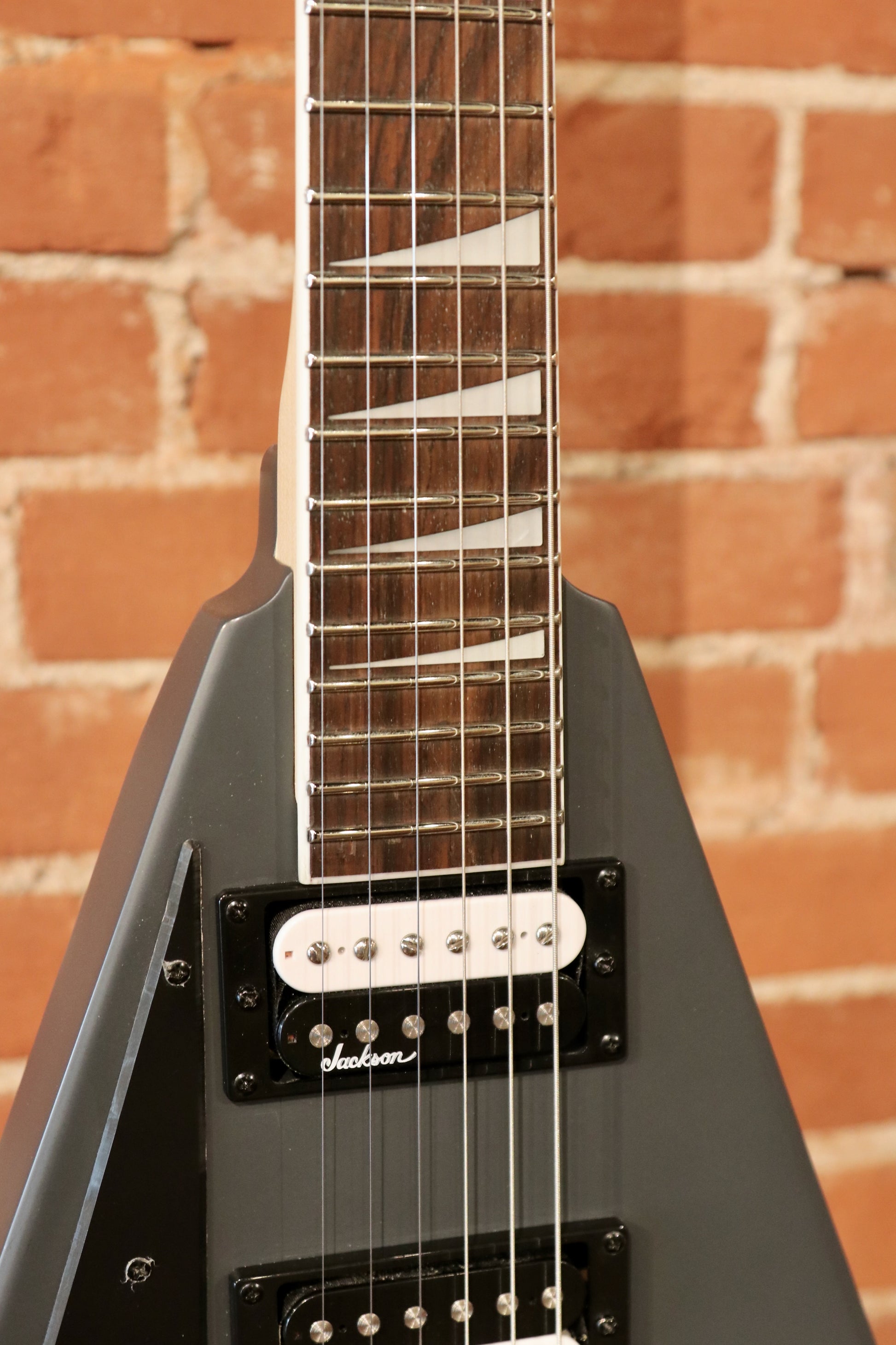 Jackson left handed guitar in matte black finish, front view showcasing the fretboard and pickups