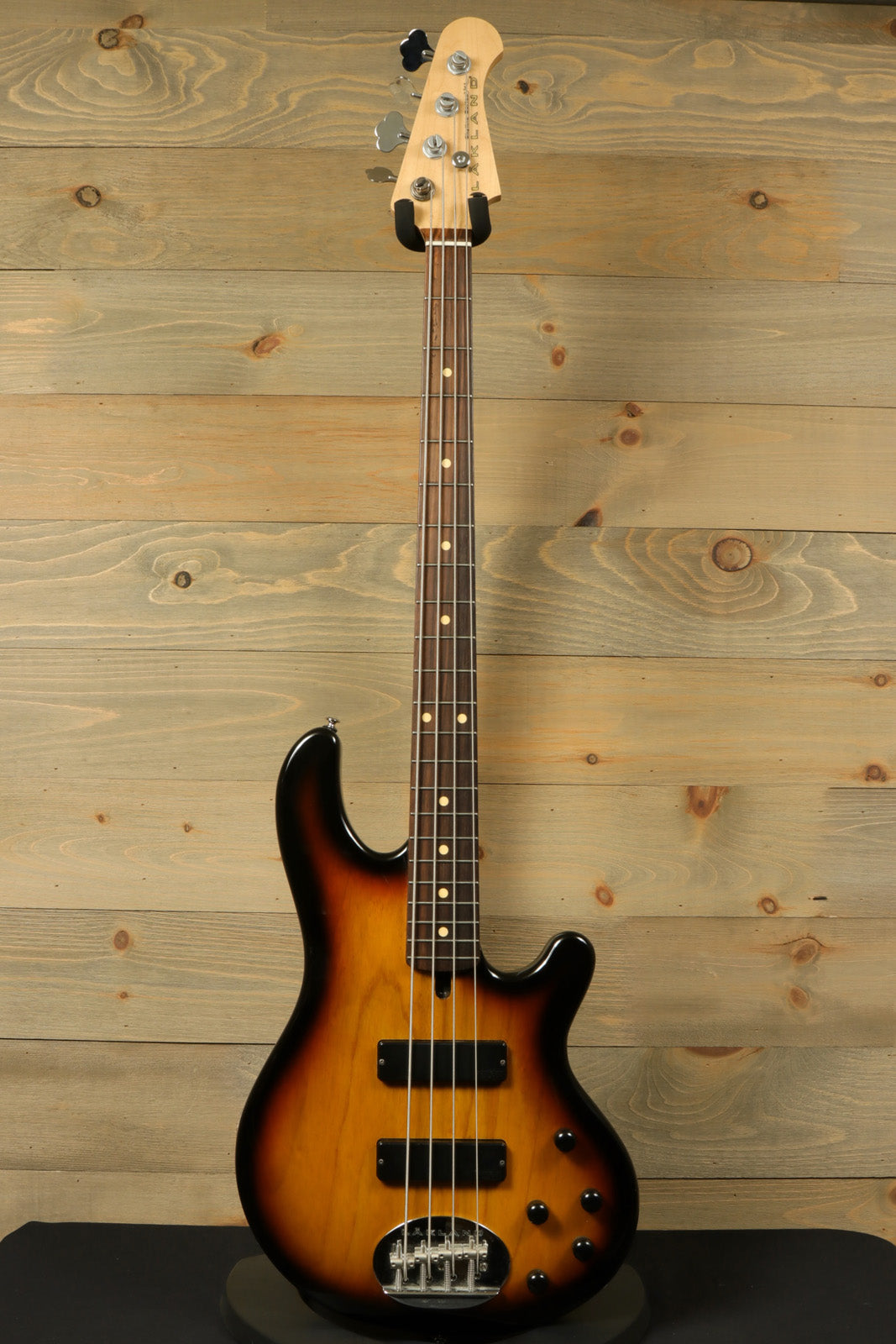Lakland Skyline 44-01 bass guitar in sunburst finish, front view on rustic wood background