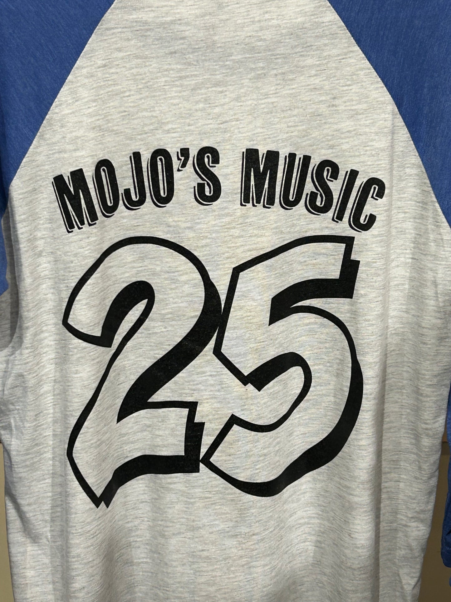 Mojo's 25th Anniversary baseball tee featuring a bold 25 print in black on a gray background