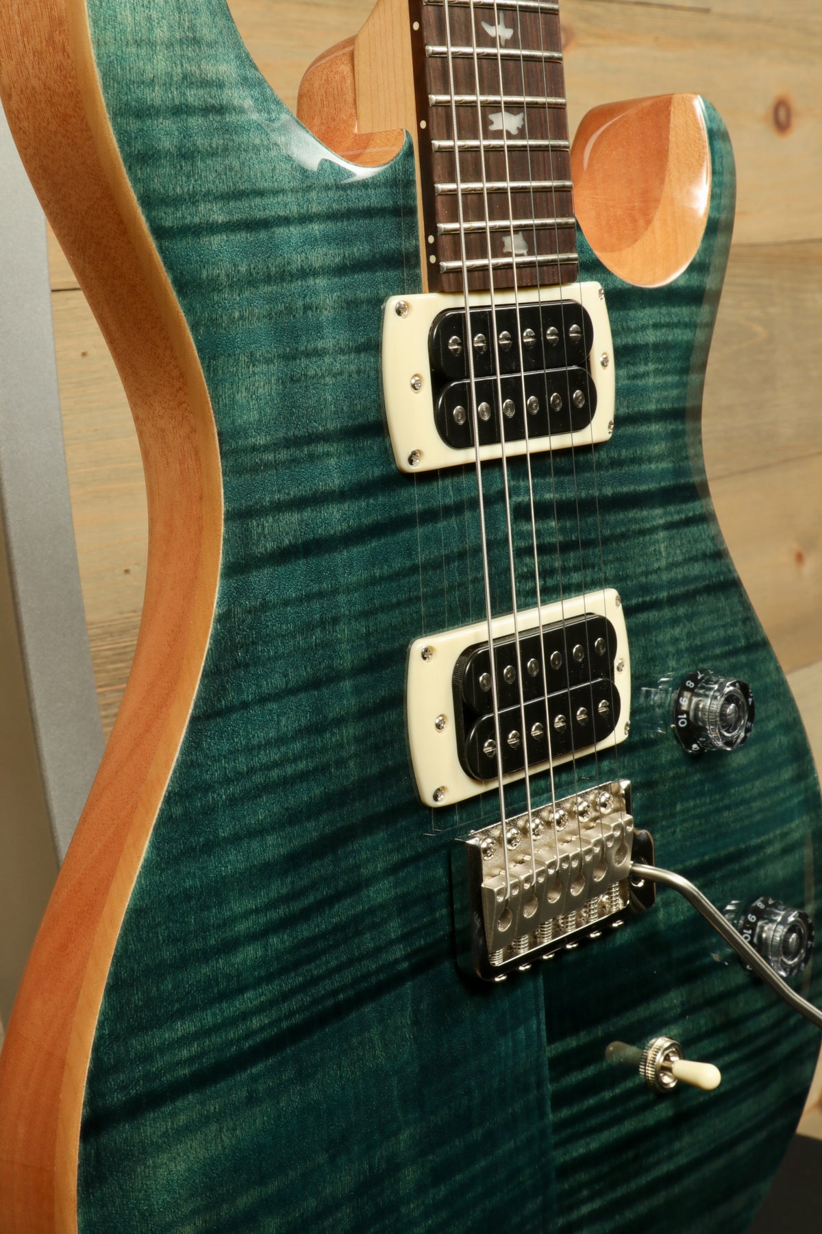 PRS electric guitar in teal with a flame finish, showcasing the body and pickup details