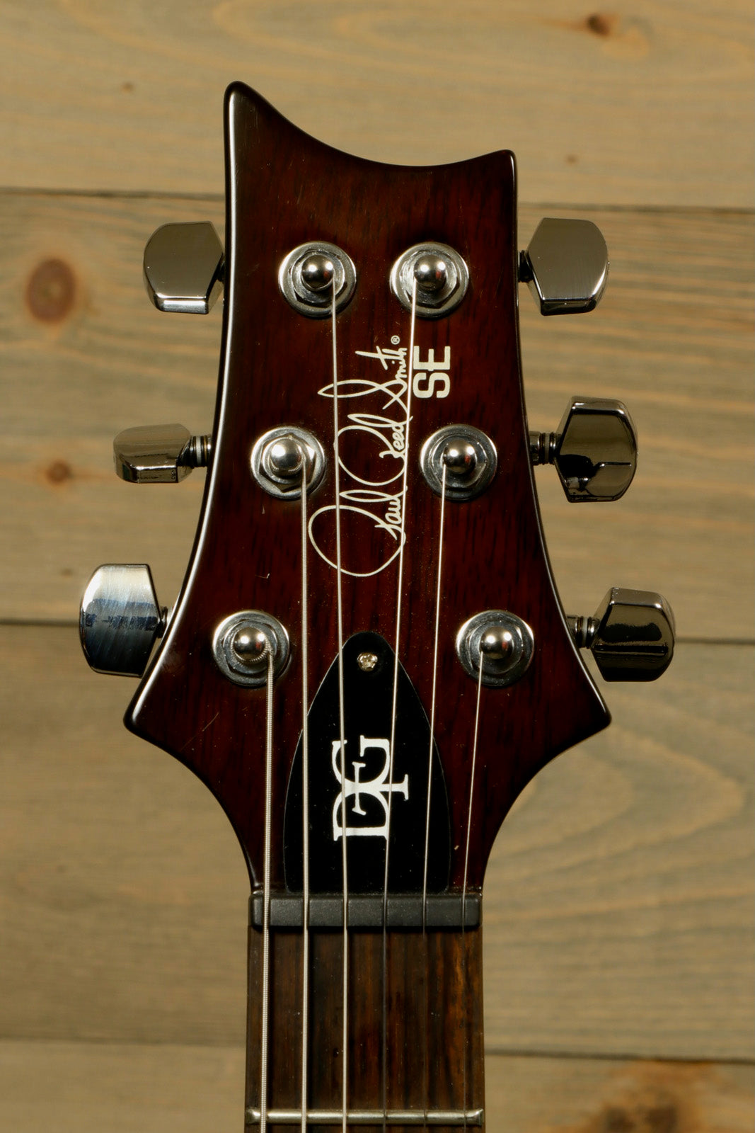 Paul Reed Smith SE DGT Sunburst with PRS Gig Bag showcasing the headstock and tuning pegs
