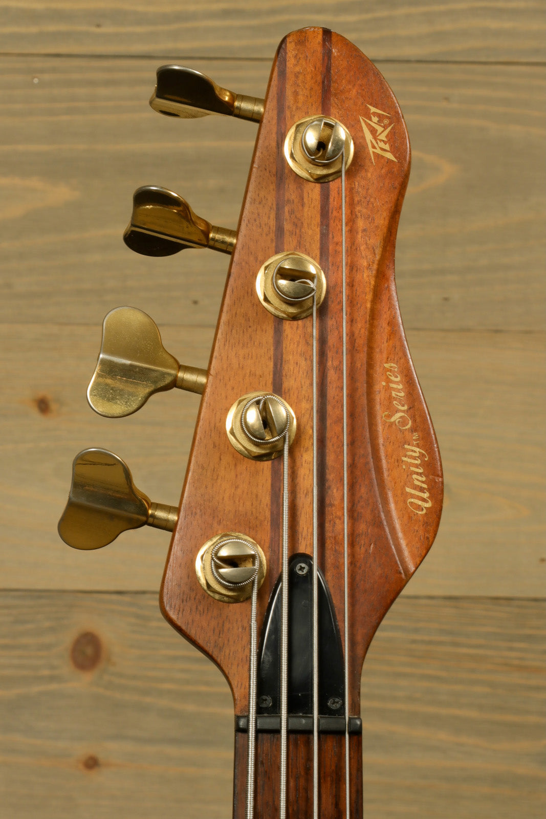 Peavey Vintage Peavey Unity Koa Bass, headstock view with golden tuning pegs and koa wood finish